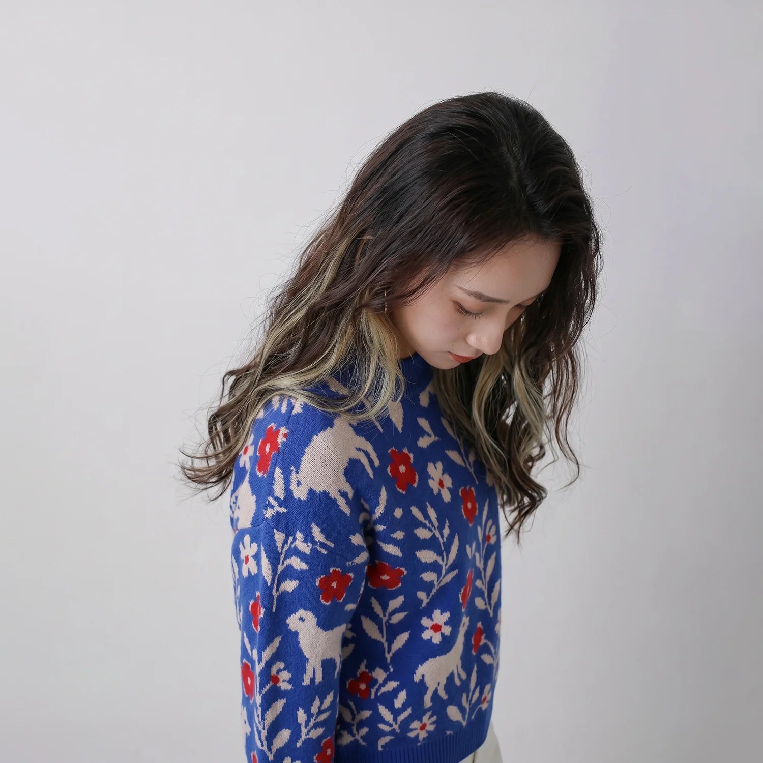 Close-up of the blue merino wool jumper with sheep, red flowers and leafy motifs.