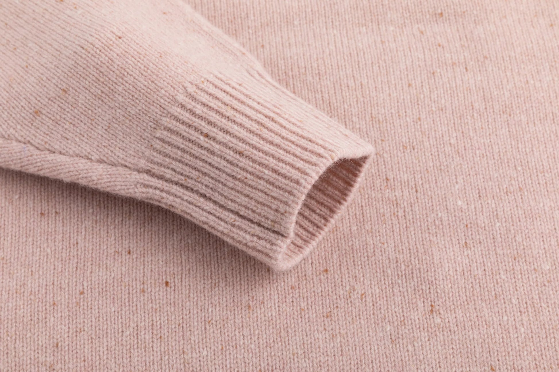 Close-up of the ribbed cuff on the blush pink jumper.