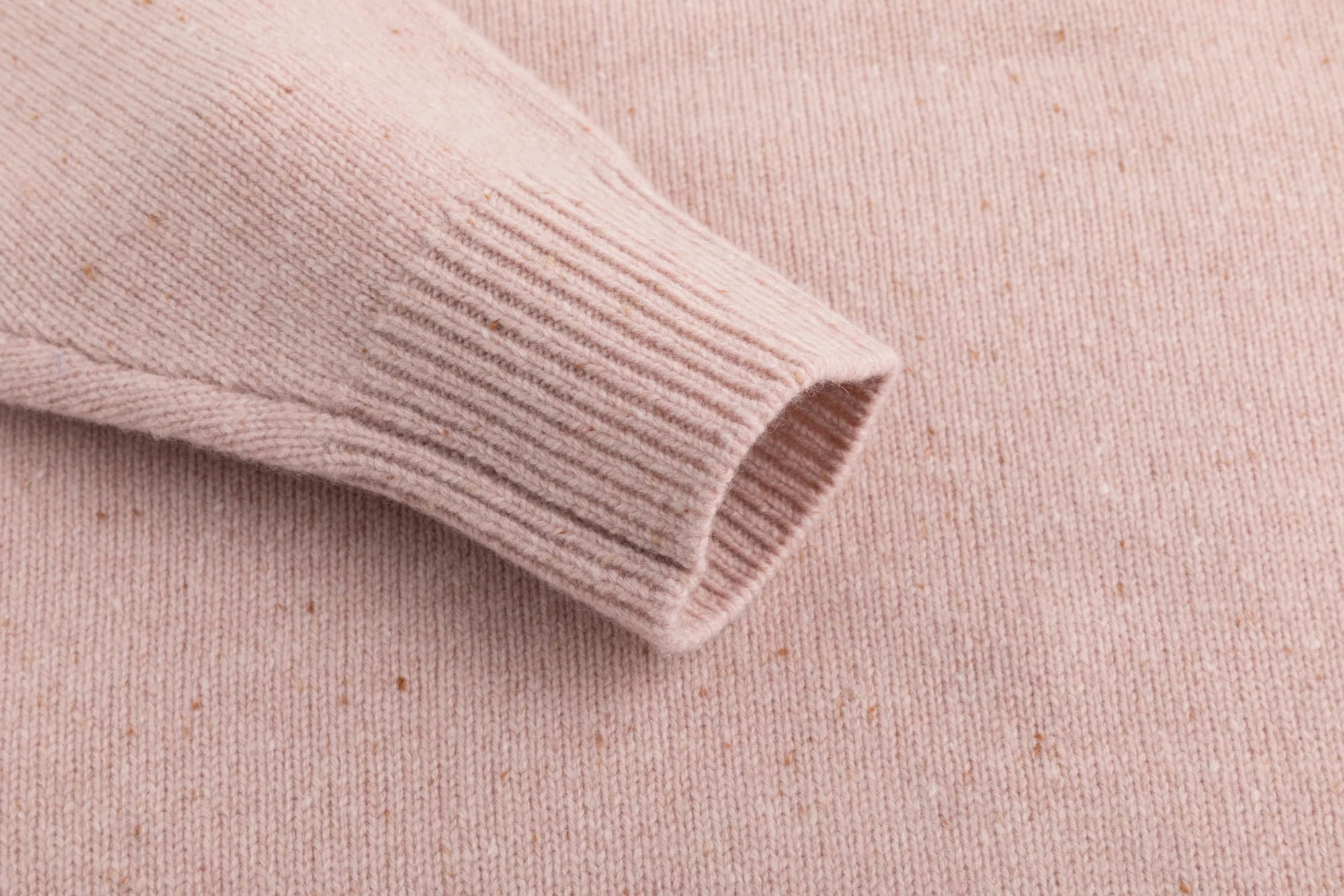 Close-up of the ribbed cuff on the blush pink jumper.