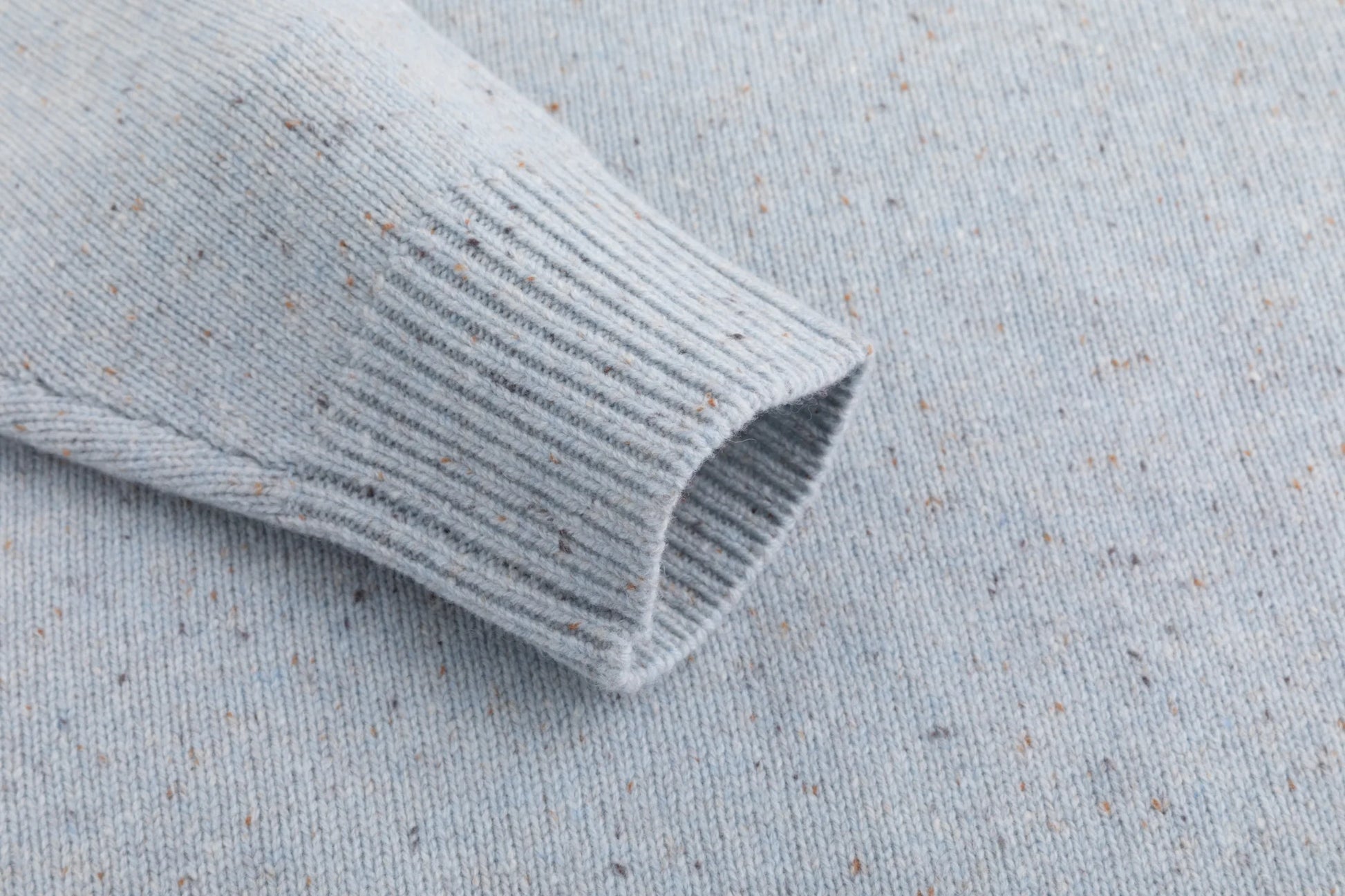 Close-up of the ribbed cuff on the light blue jumper.