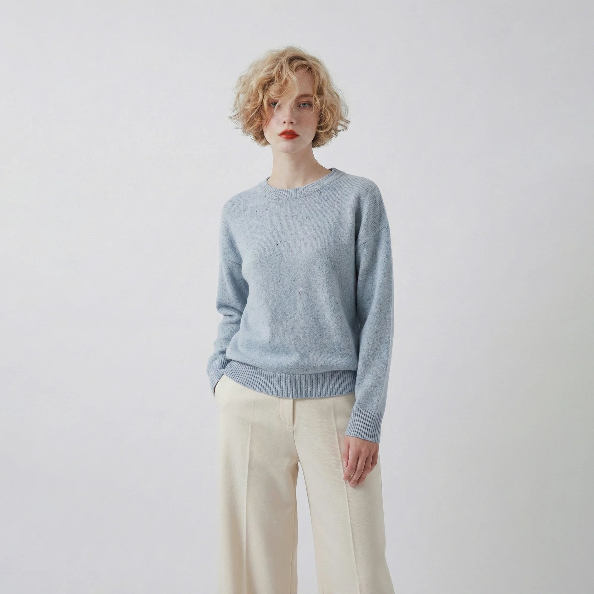 Model wearing a light blue jumper with a crew neck and a slightly oversized fit.