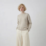 Model wearing an oatmeal jumper with a crew neck and a slightly oversized fit.