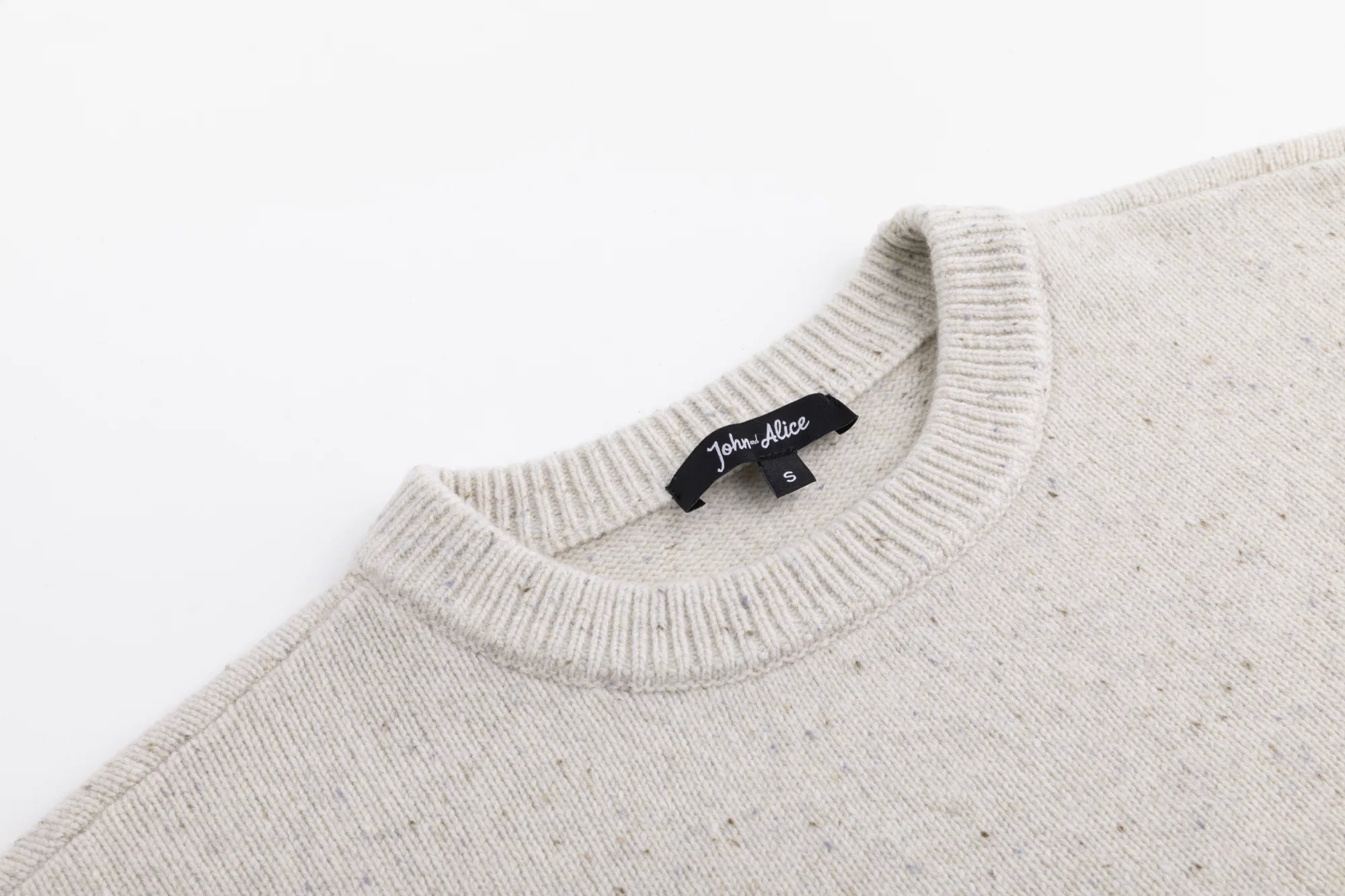 Close-up of the crew neckline on the oatmeal jumper.