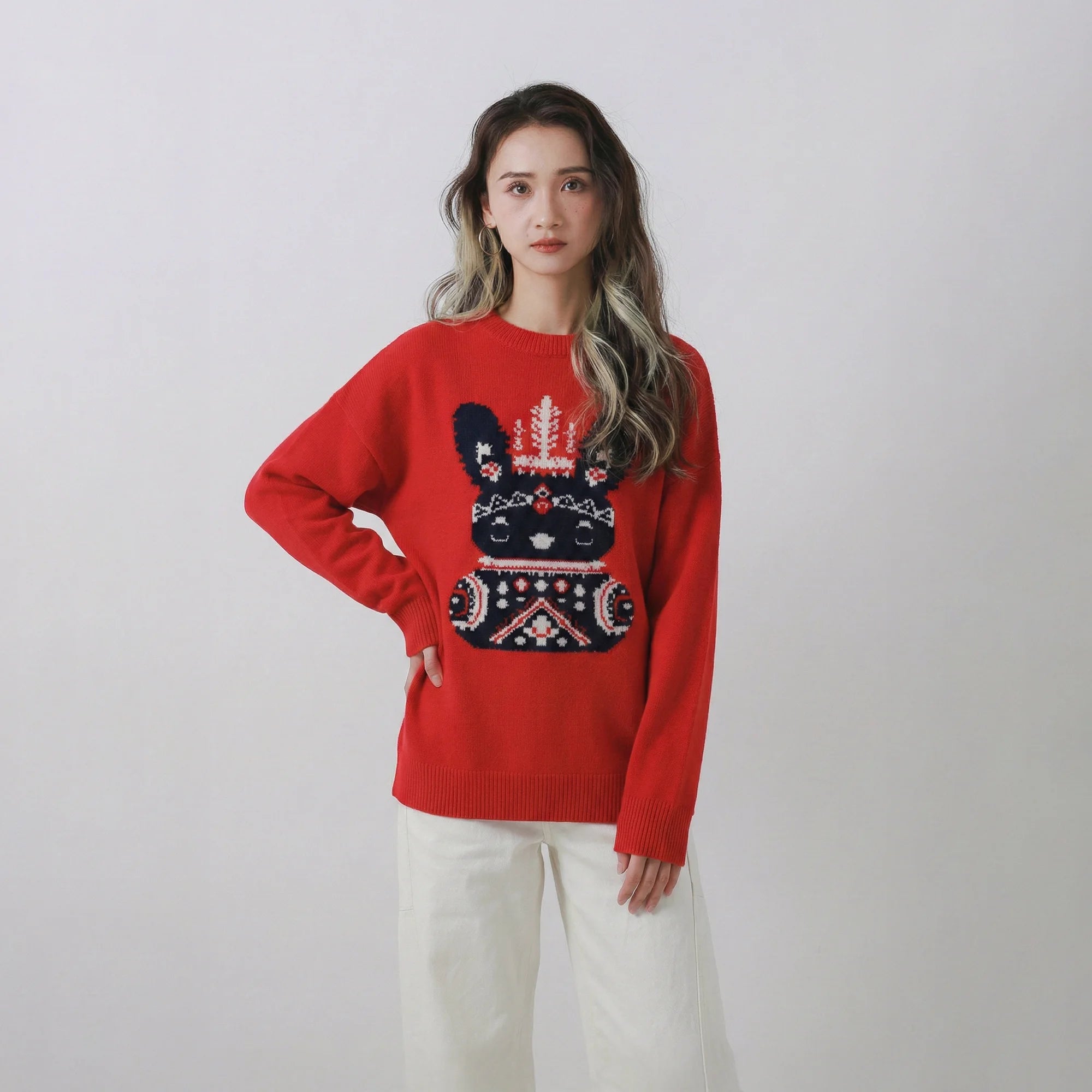Model wearing a red jumper with an oversized fit and pixel-style bunny jacquard on the front.