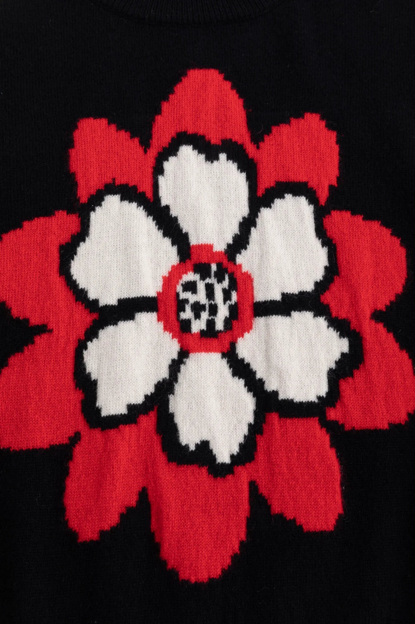 Close-up of the abstract flower jacquard on the black knit top.