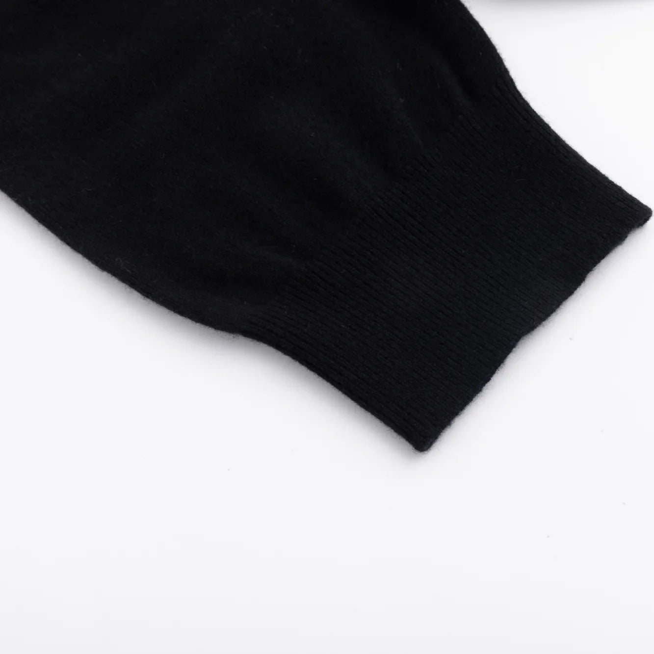 Close-up of the ribbed short-sleeve cuff on the black knit top.