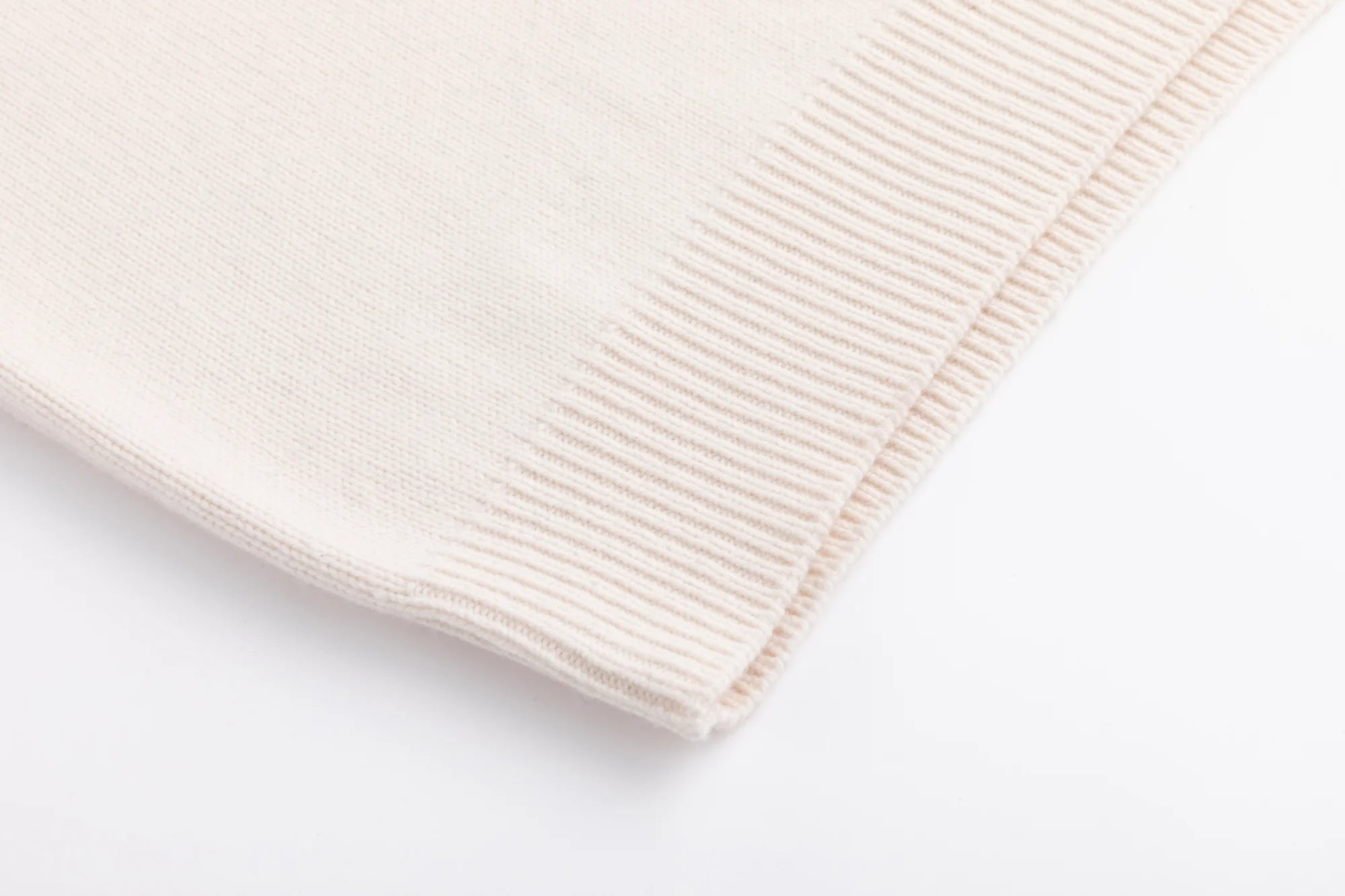 Close-up of the ribbed hem on the cream jumper.
