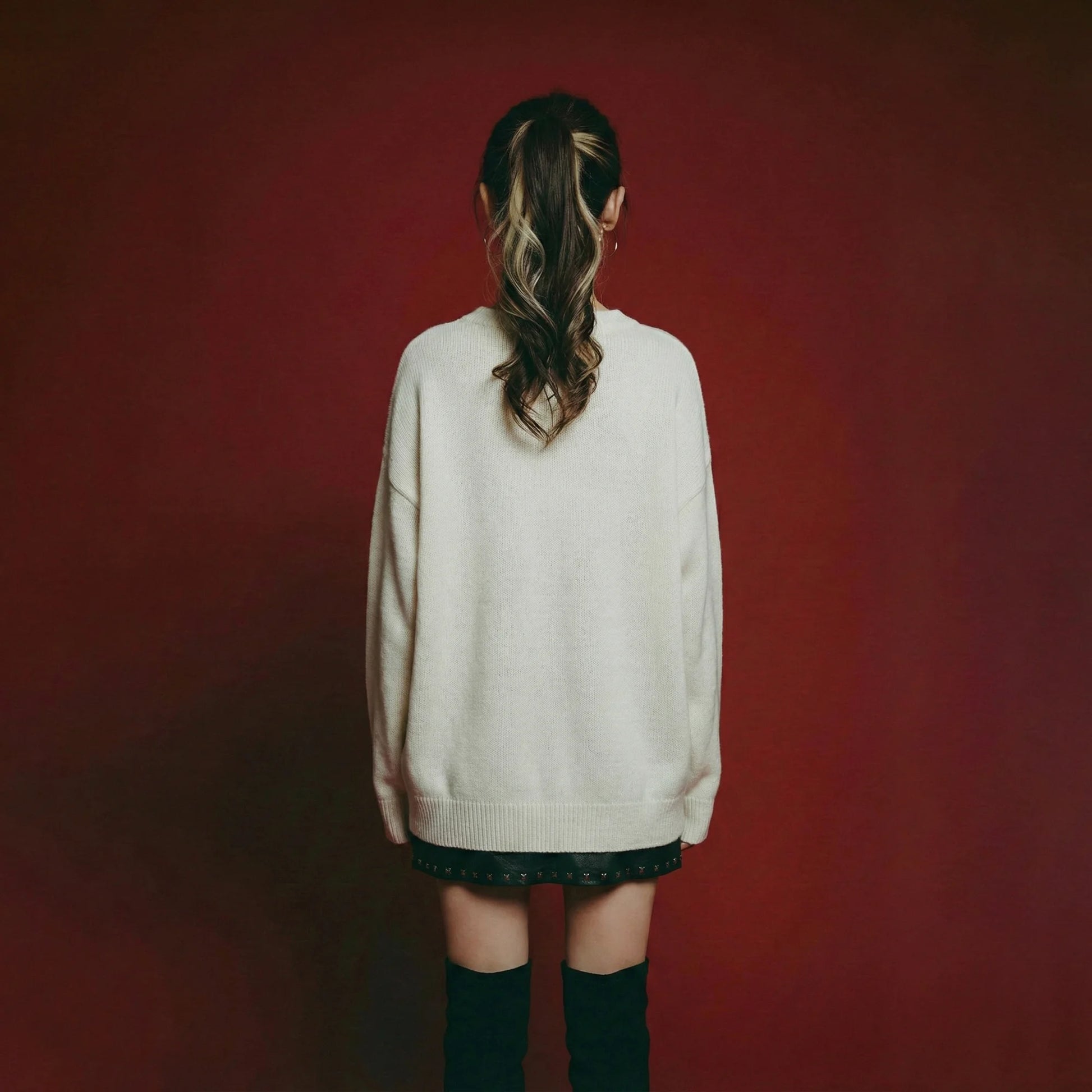 Back view of model wearing a cream oversized jumper with a plain back and ribbed trims.