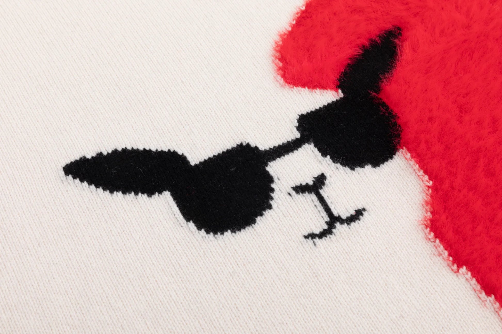 Close-up of the llama face motif with black sunglasses and the bright red fuzzy heart panel on the cream jumper.
