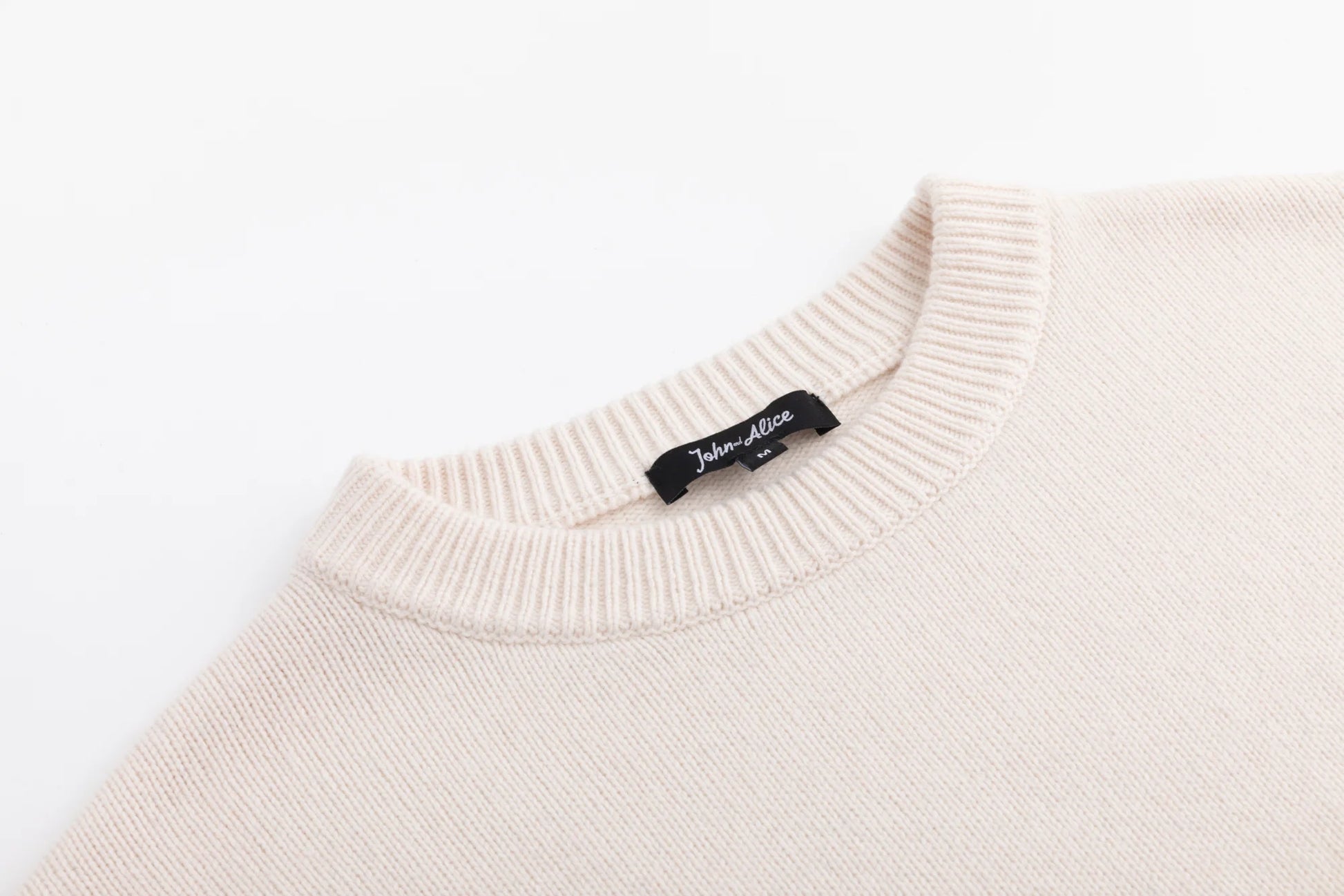 Close-up of the crew neckline on the cream oversized jumper.