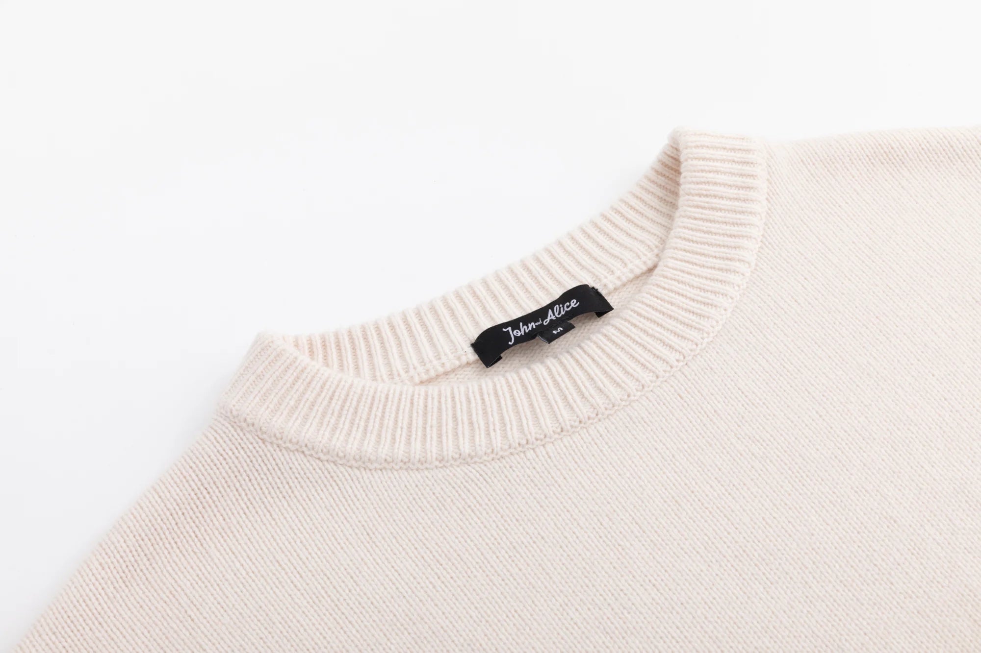 Close-up of the crew neckline on the cream oversized jumper.