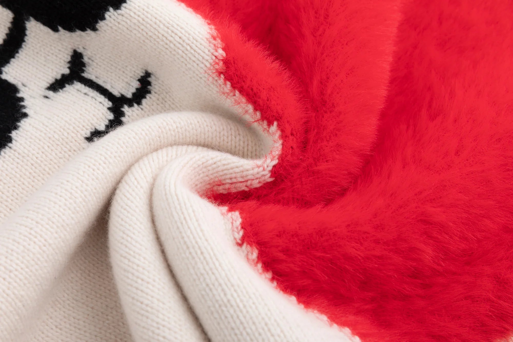 Close-up of the knit texture and bright red fuzzy heart panel on the cream jumper.