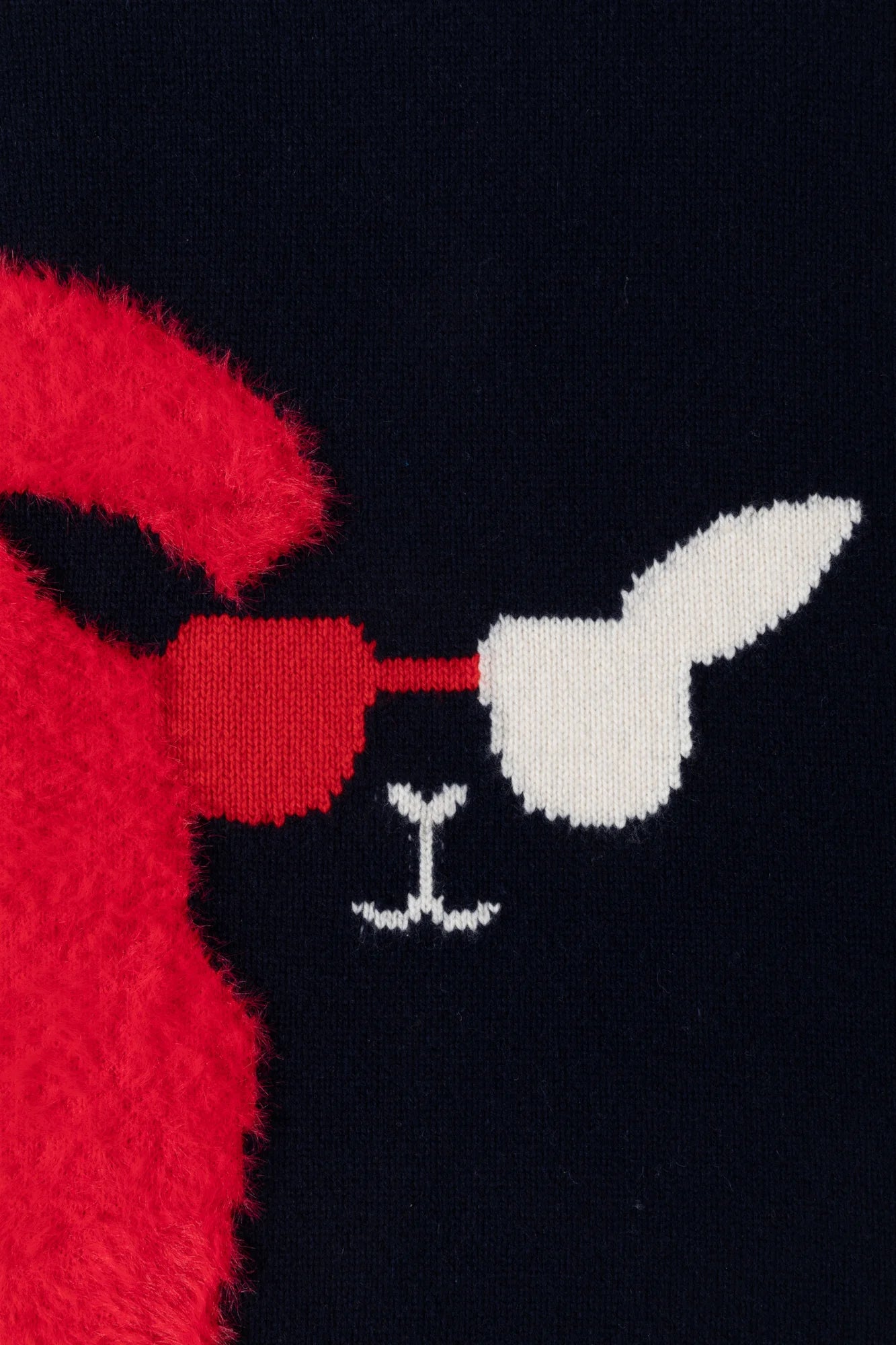 Close-up of the llama face motif and bright red fuzzy heart panel on the navy jumper.