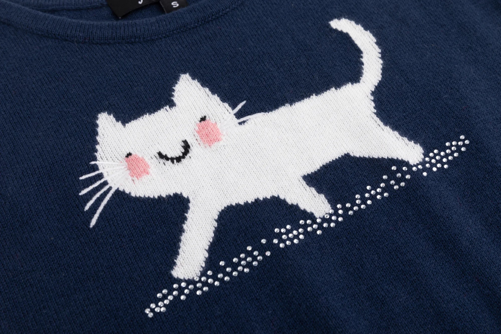 Close-up of the white cat motif and rhinestone accents on the navy knit tank.