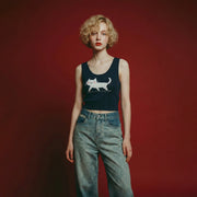 Model wearing a navy knit tank with a white cat motif on the front and rhinestone accents beneath the paws.