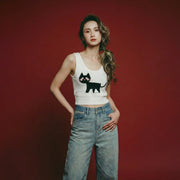 Woman wearing an ivory knit tank with a scoop neckline and black cat jacquard on the front.