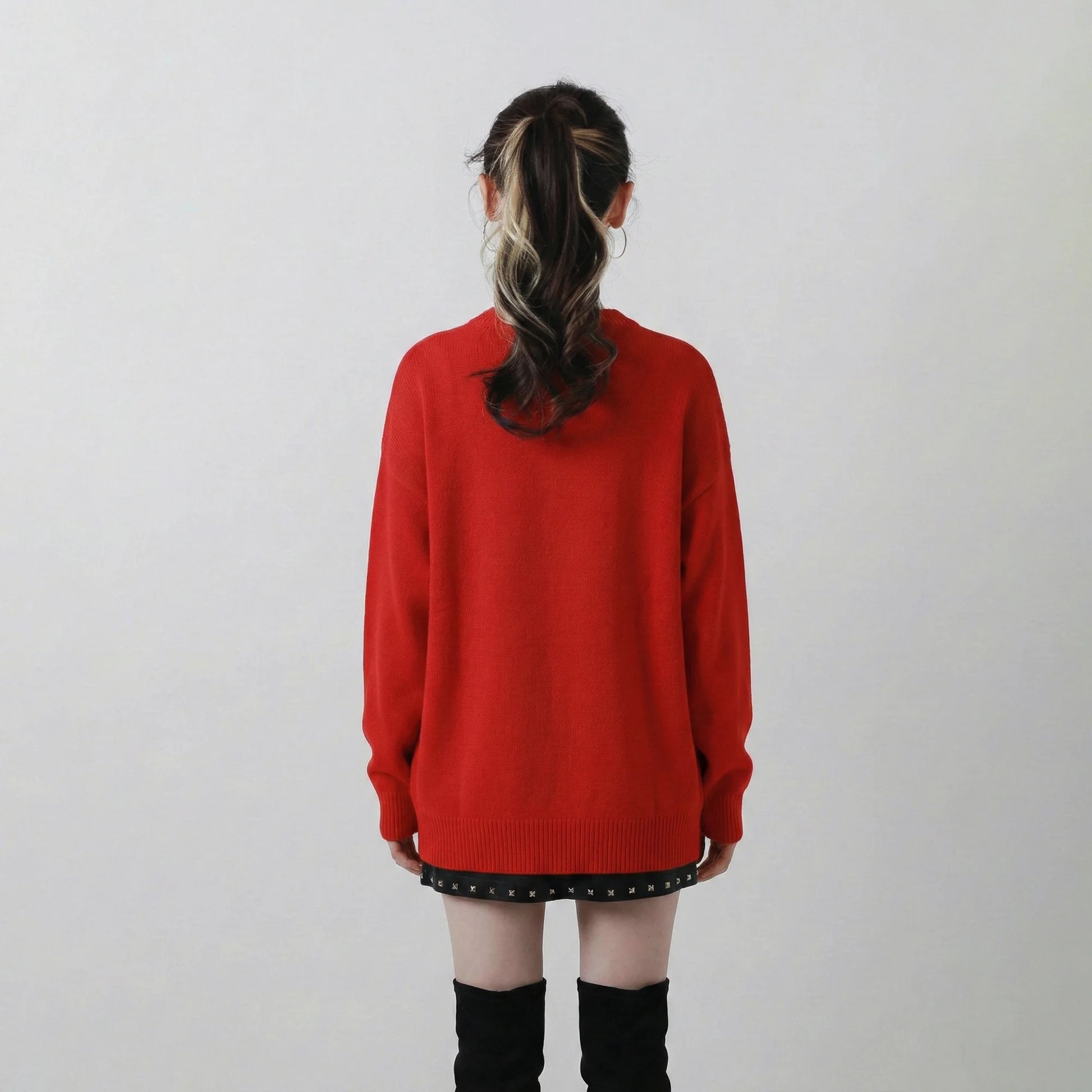 Back view of model wearing a red oversized jumper in a wool blend knit.