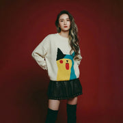 Model wearing an oversized ivory cotton and wool blend jumper with an abstract cat jacquard on the front and distressed ribbed trims.