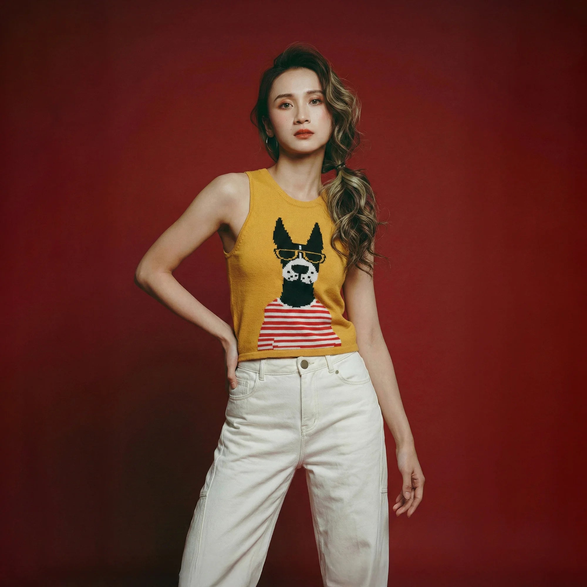 Model wearing a mustard yellow cotton knit tank with a dog jacquard on the front.