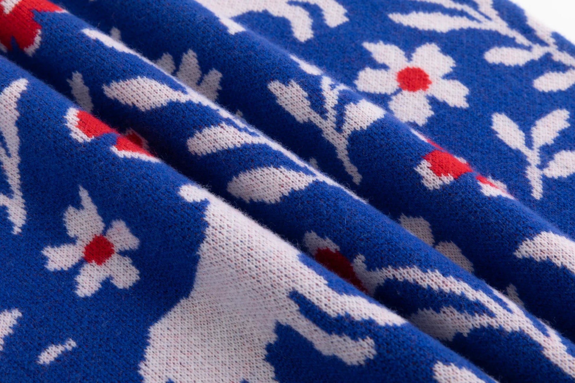 Close-up of the wool knit texture and all-over jacquard on the cobalt blue jumper.
