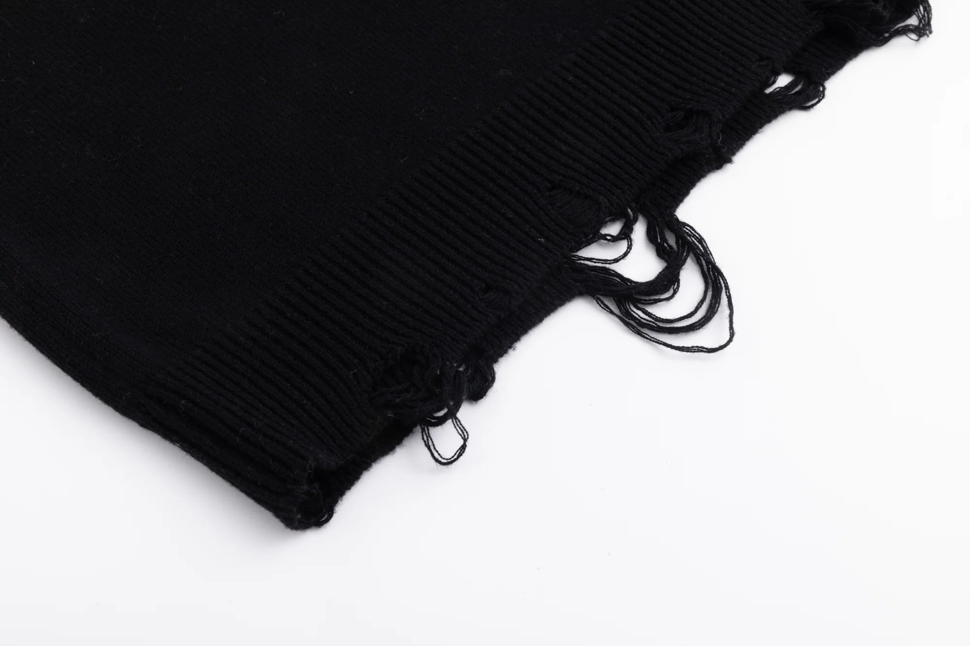 Close-up of the distressed ribbed hem on the black jumper.