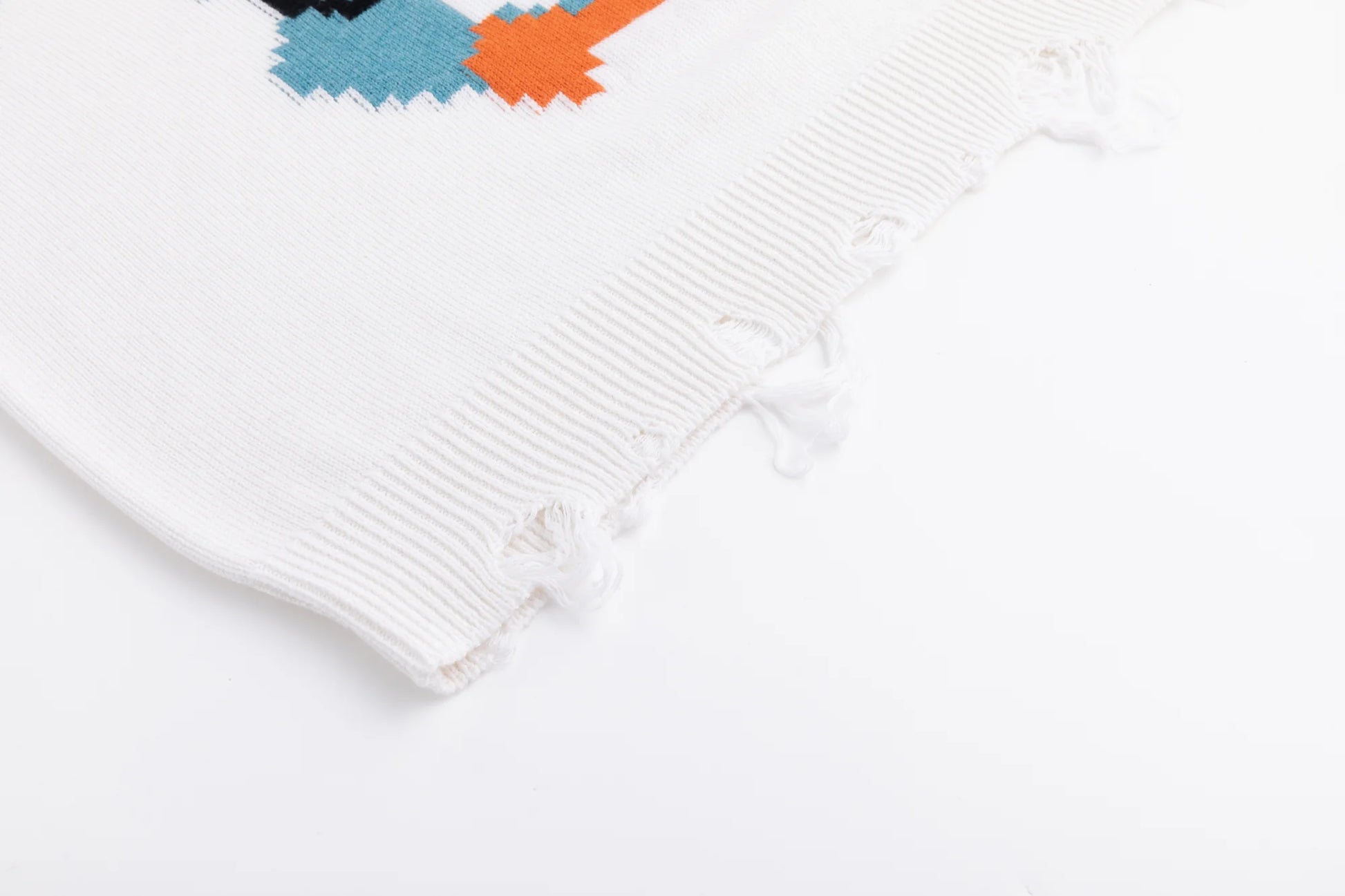 Close-up of the distressed ribbed hem on the ivory jumper.