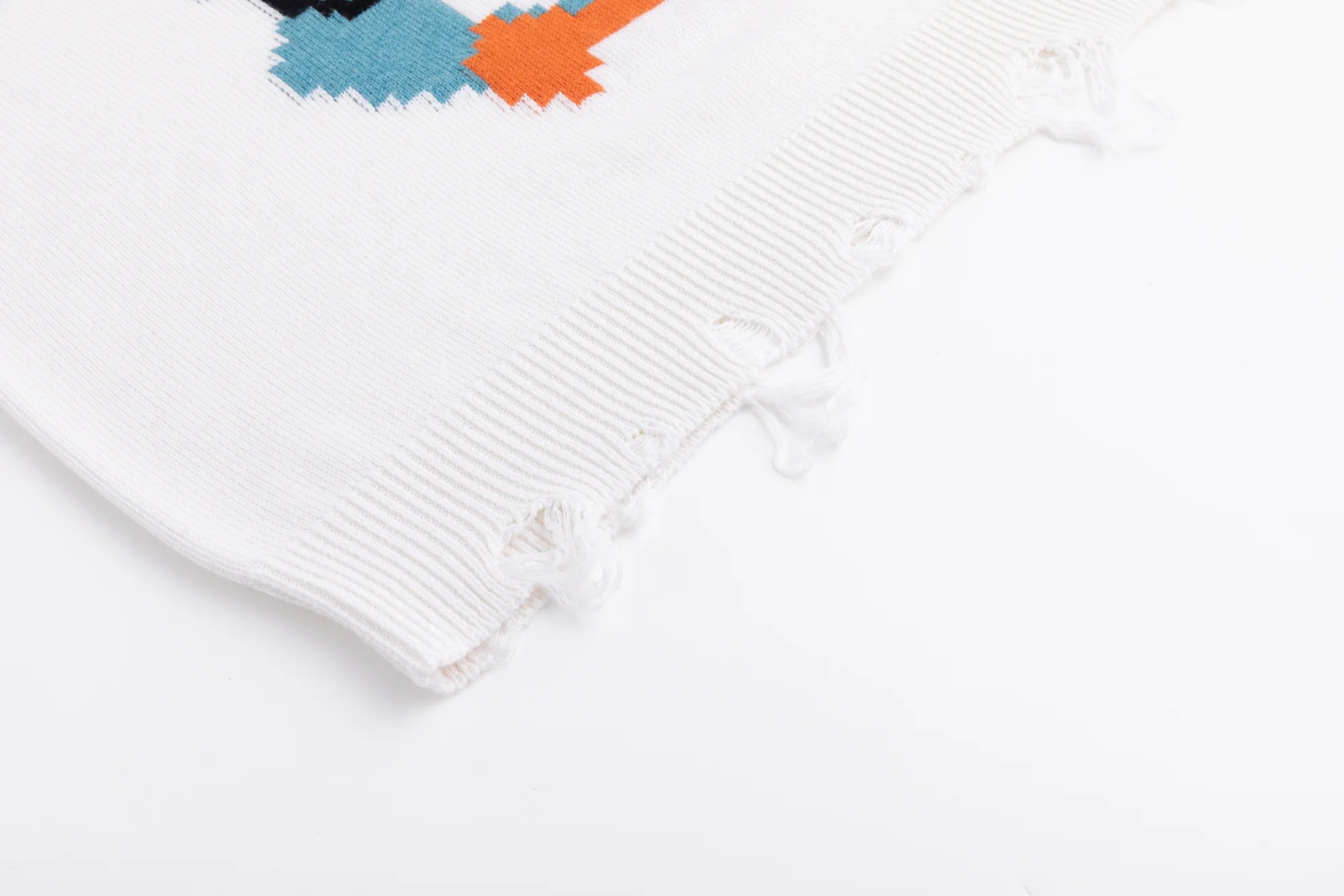 Close-up of the distressed ribbed hem on the ivory jumper.