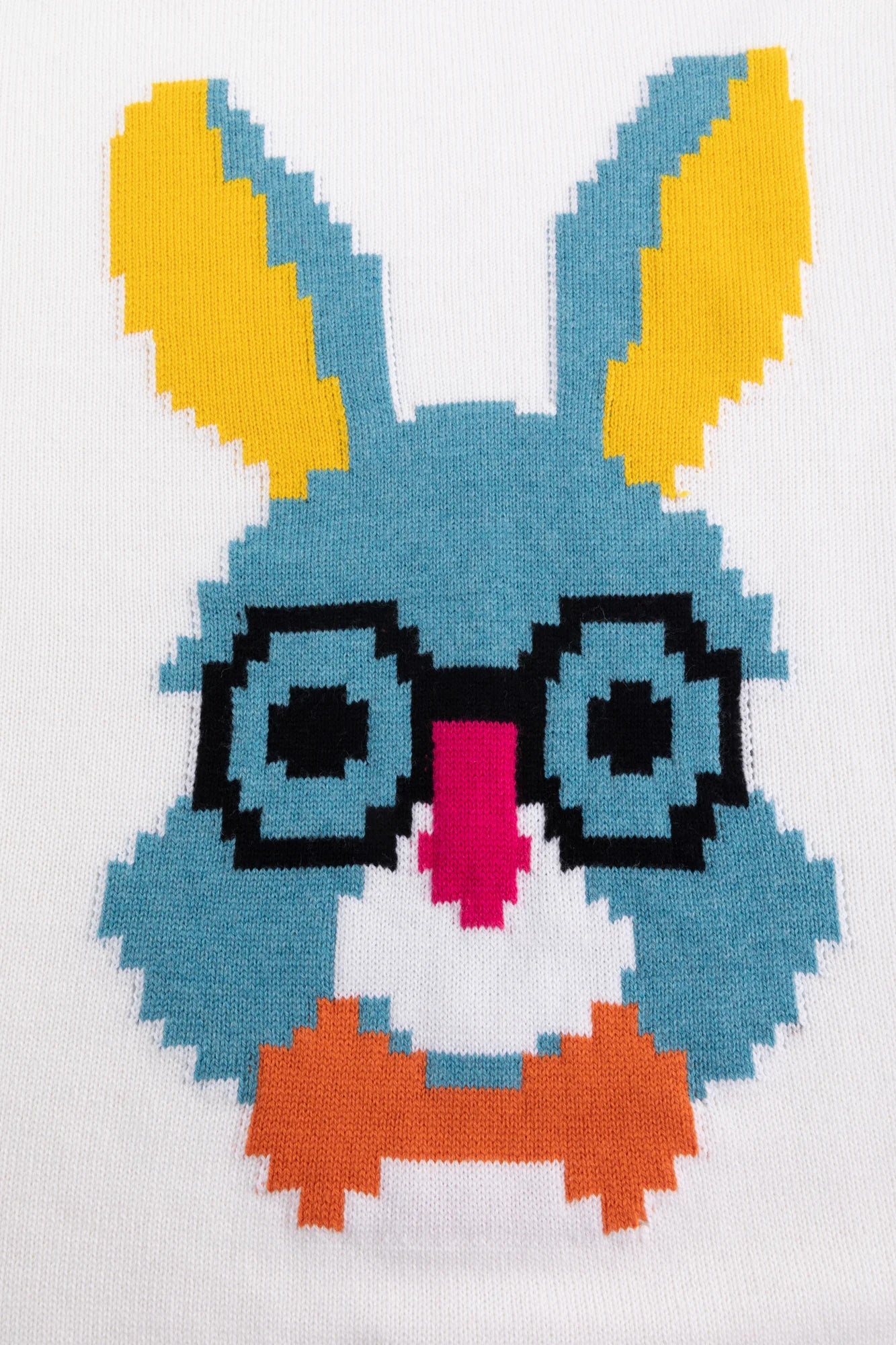 Close-up of the pixel-style rabbit face motif with glasses on the ivory jumper.