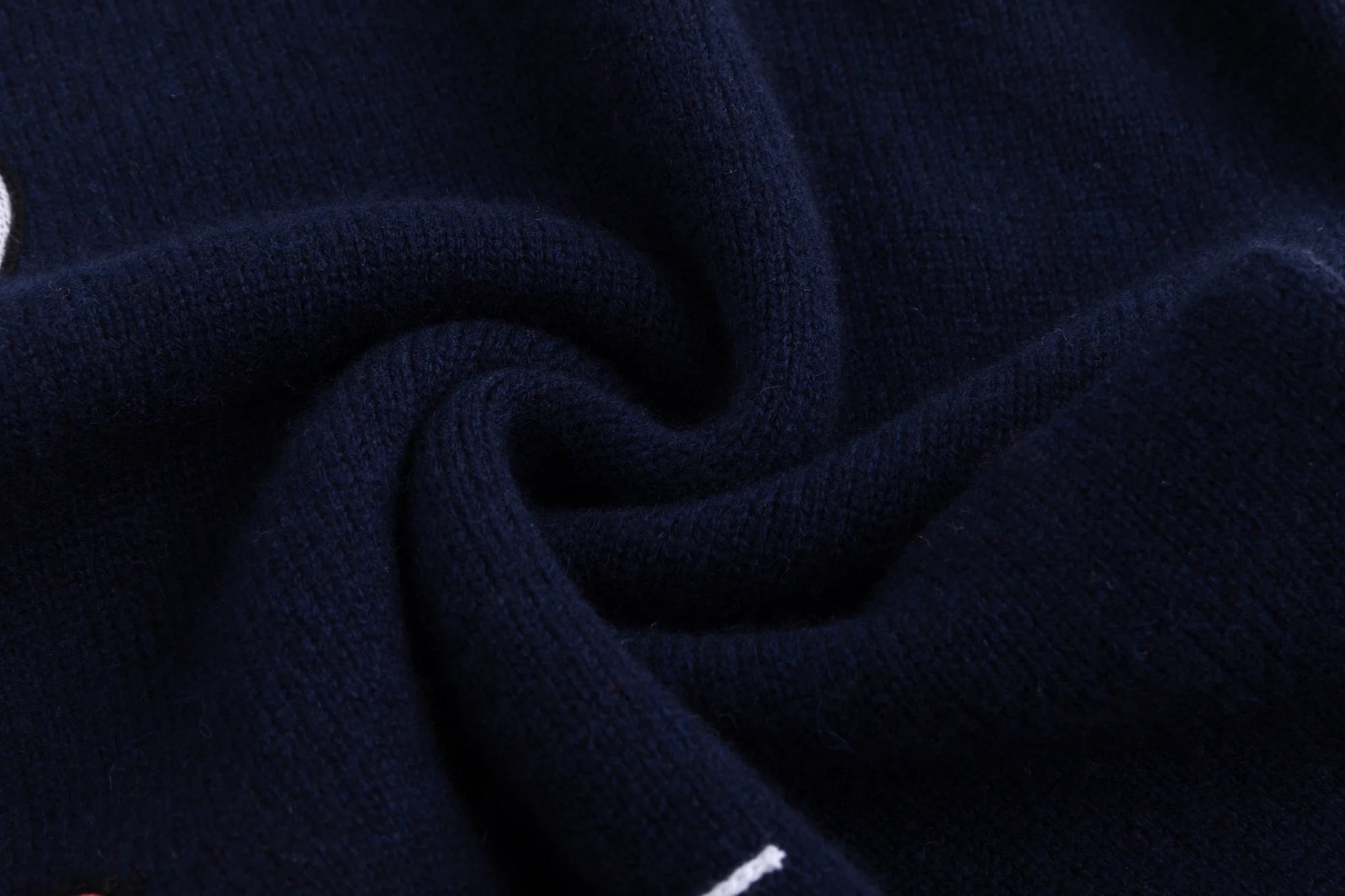 Close-up of the soft wool knit texture on the navy jumper.