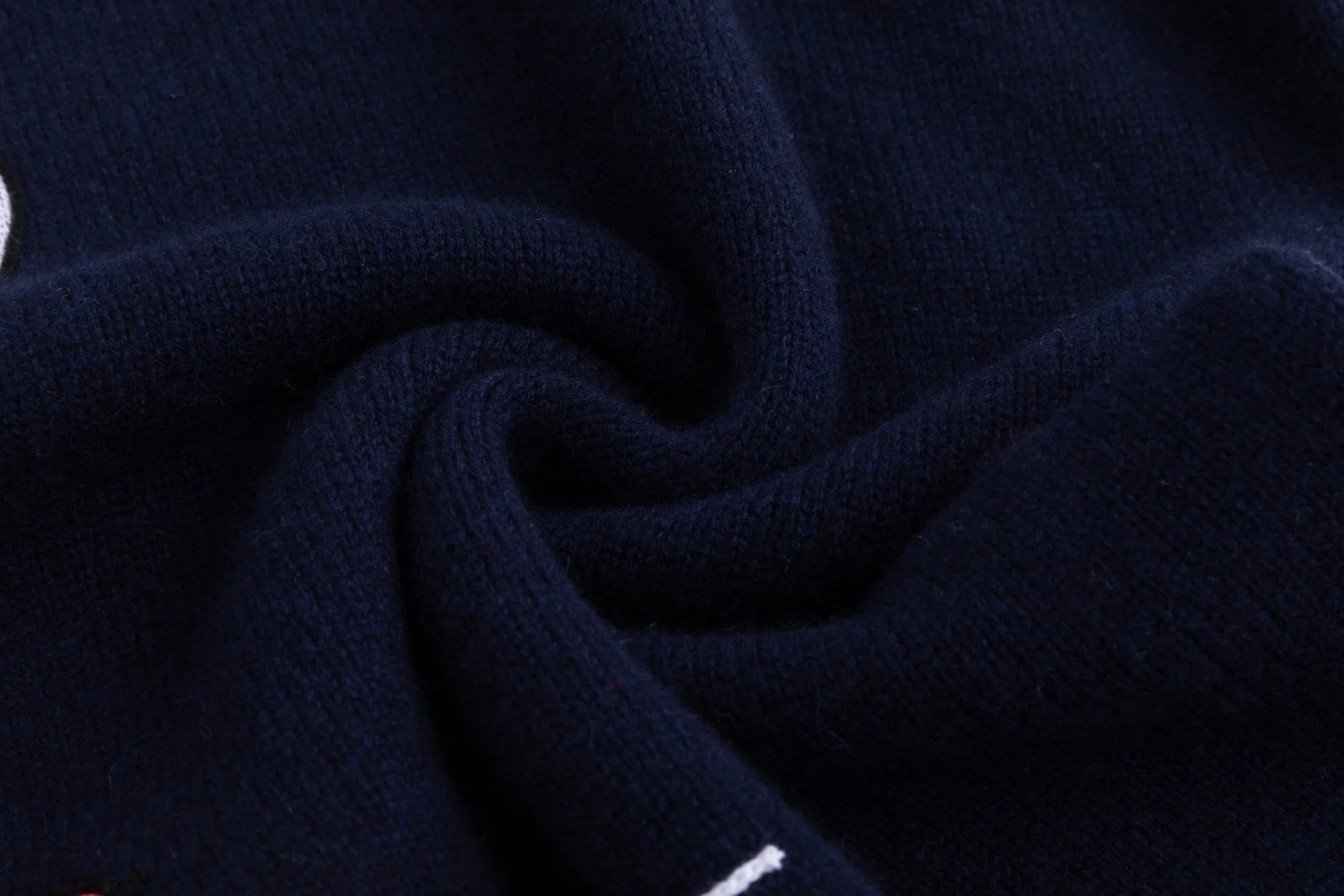 Close-up of the soft wool knit texture on the navy jumper.