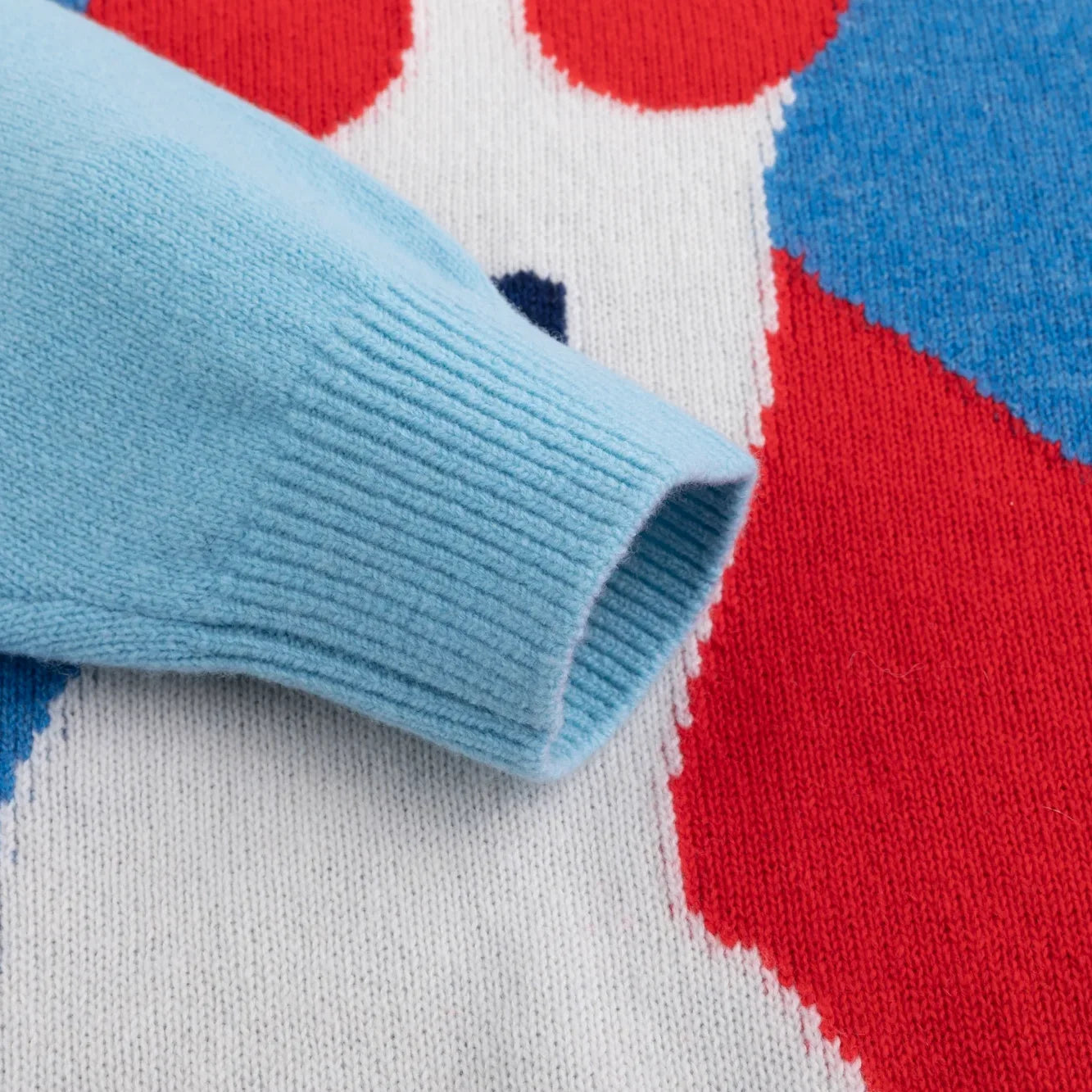 Close-up of the light blue ribbed cuff beside the dog intarsia.