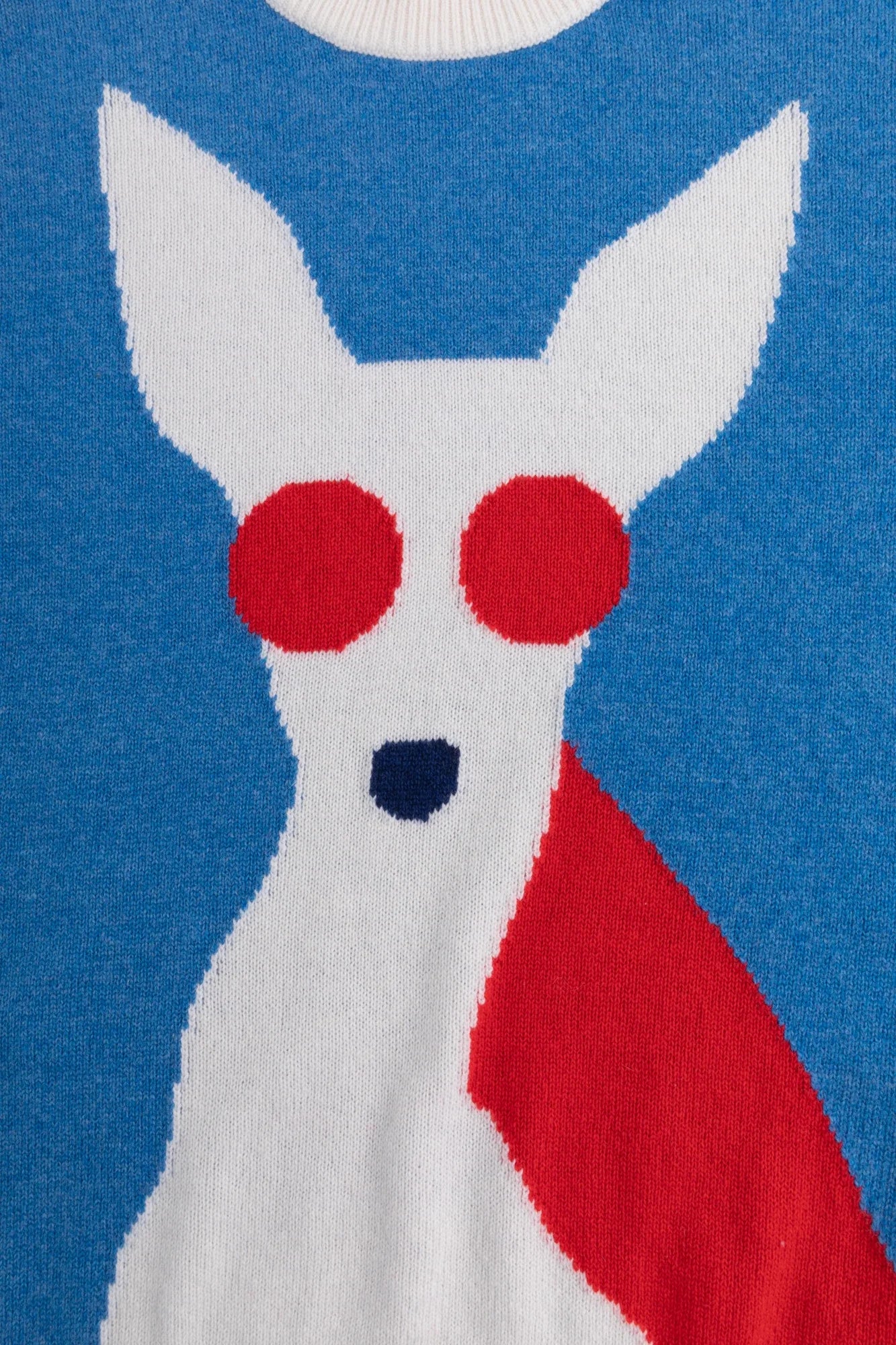 Close-up of the contrasting dog intarsia with round red sunglasses on the blue jumper.