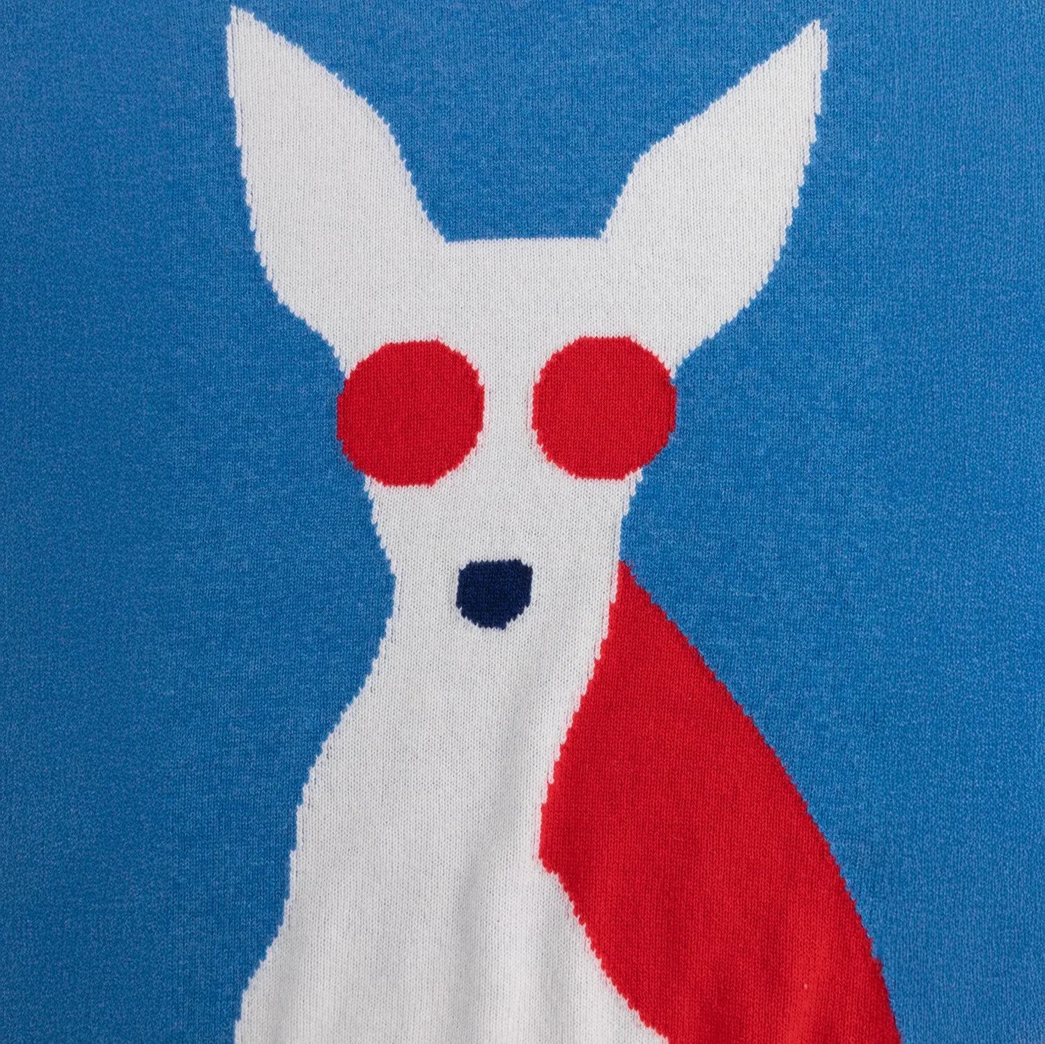 Close-up of the white dog intarsia with red sunglasses on the blue jumper.