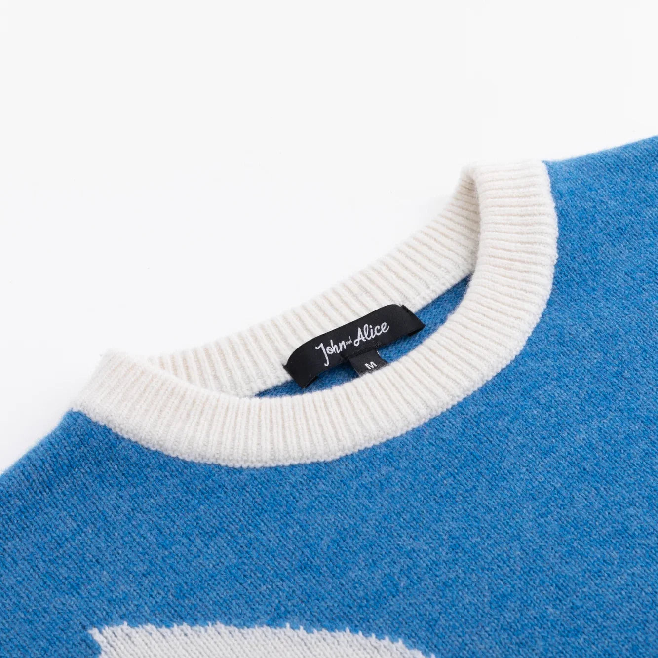Close-up of the white ribbed neckline on the blue dog intarsia jumper.