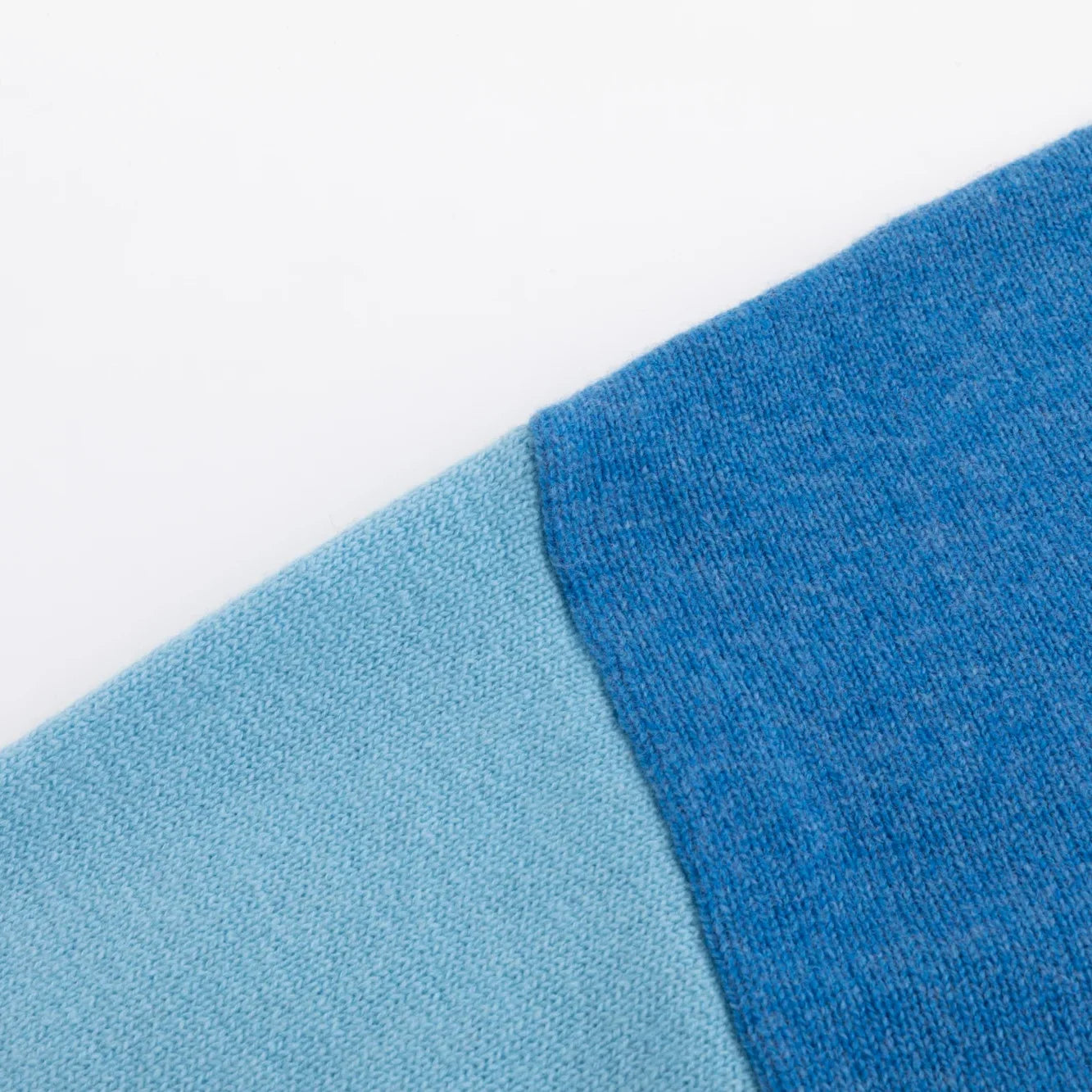 Close-up of the blue shoulder and light blue sleeve on the jumper.