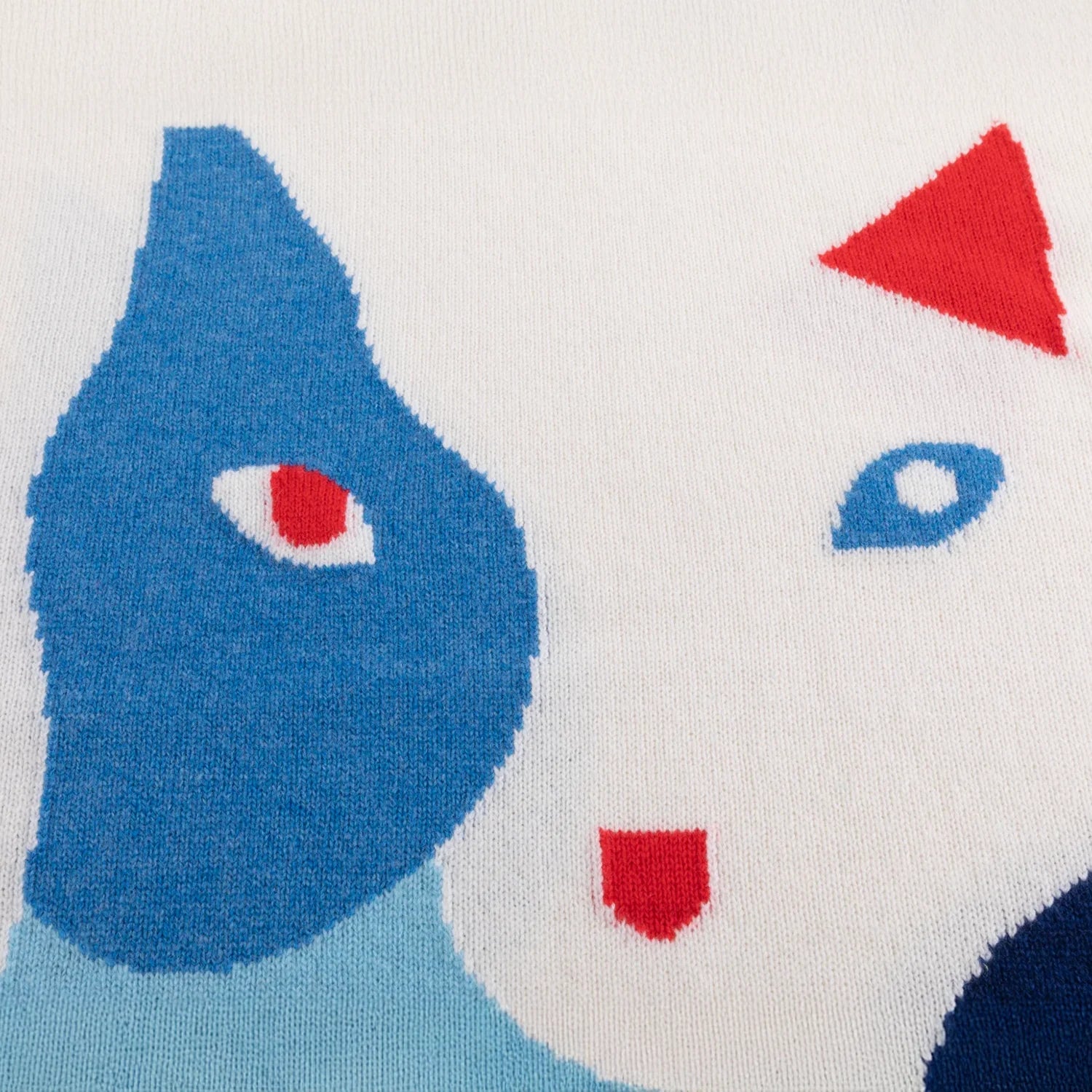 Close-up of the abstract blue cat intarsia with red facial details.