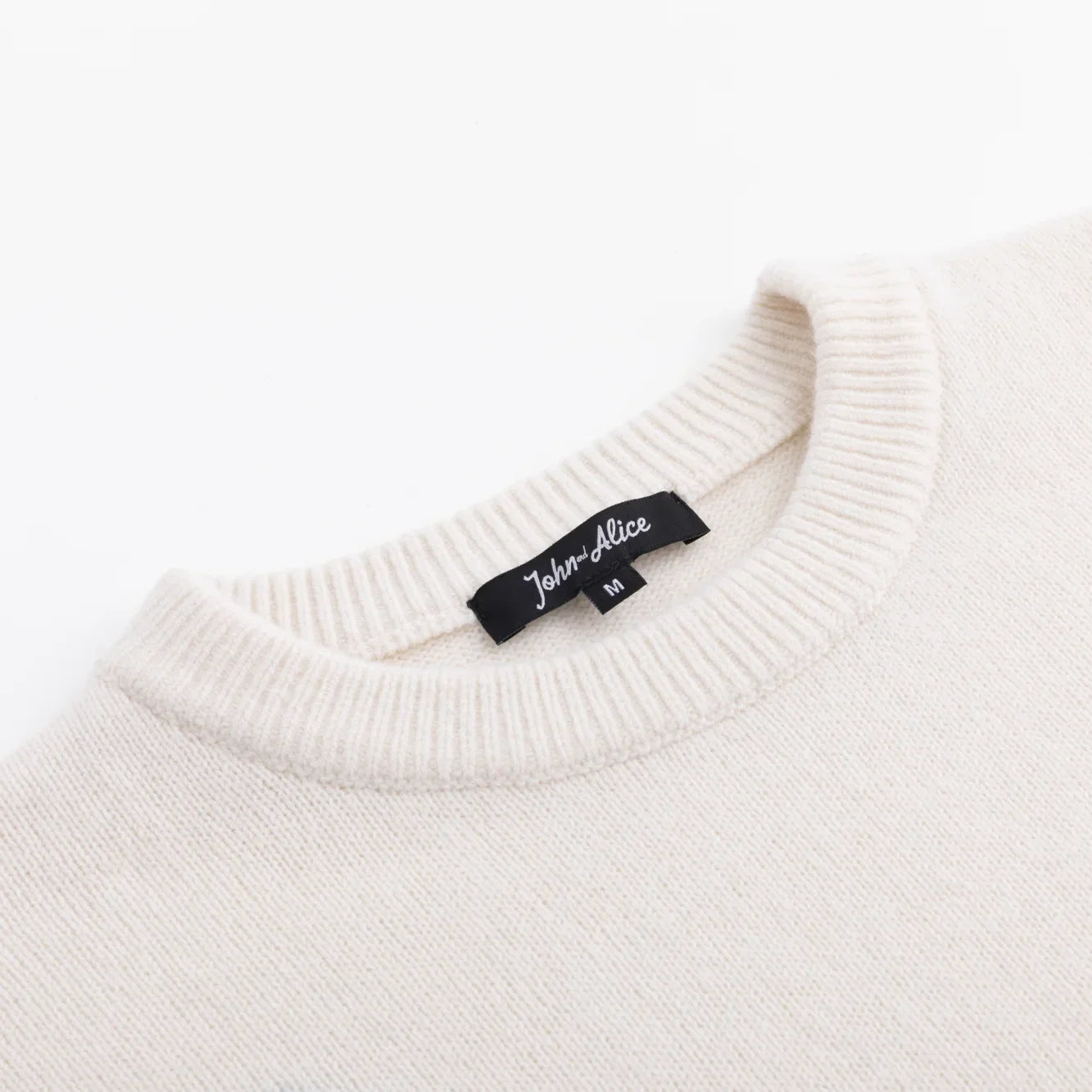 Close-up of the ivory ribbed neckline and John and Alice label.