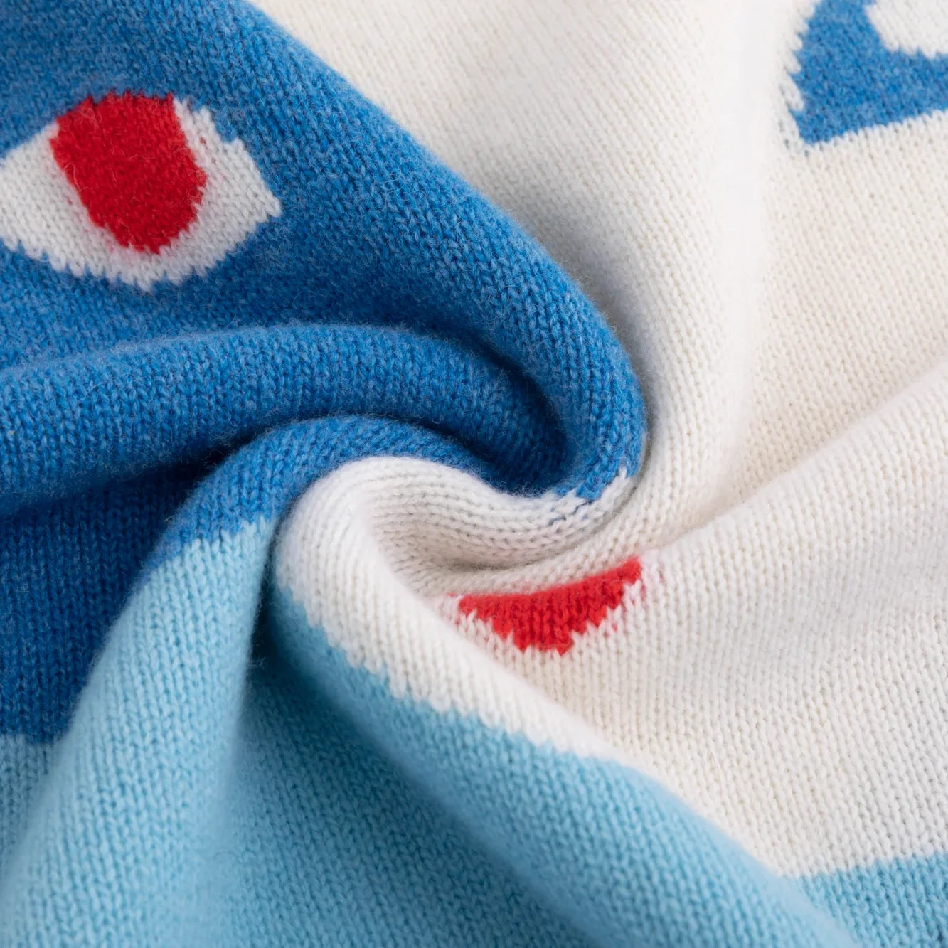 Close-up of the merino wool texture and blue, ivory and red intarsia.