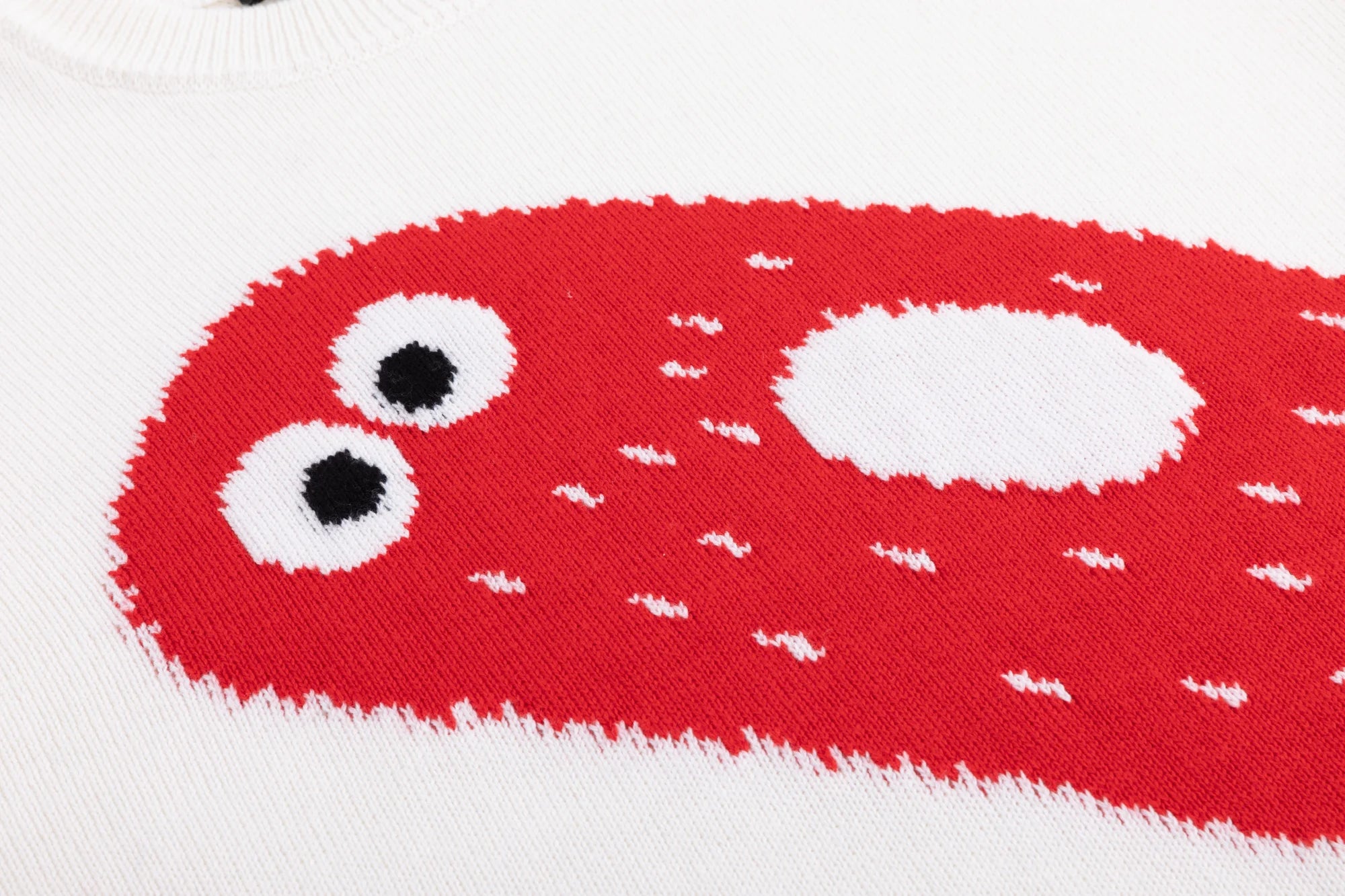 Close-up of the cute red ghost intarsia on the ivory jumper.