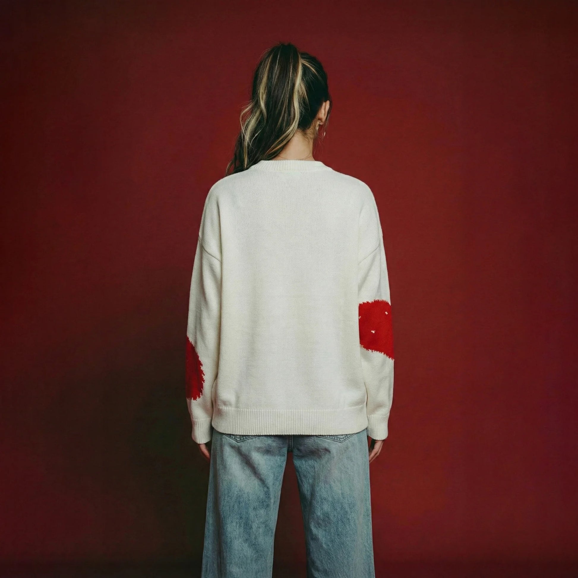 Back view of woman wearing an ivory cotton and wool blend jumper with an oversized dropped-shoulder fit.