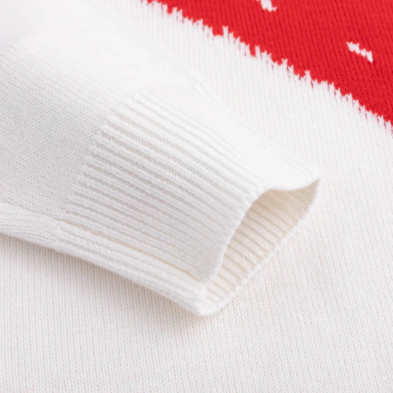 Ivory ribbed cuff beside the red knitted pattern