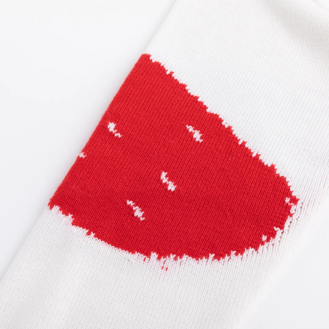 Red and white knitted pattern wrapping around the sleeve