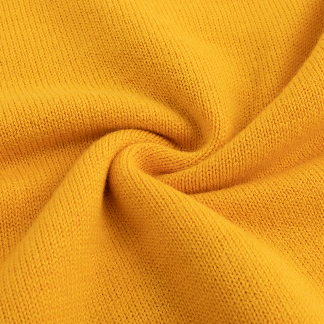 Close-up of softly folded mustard yellow knitted fabric