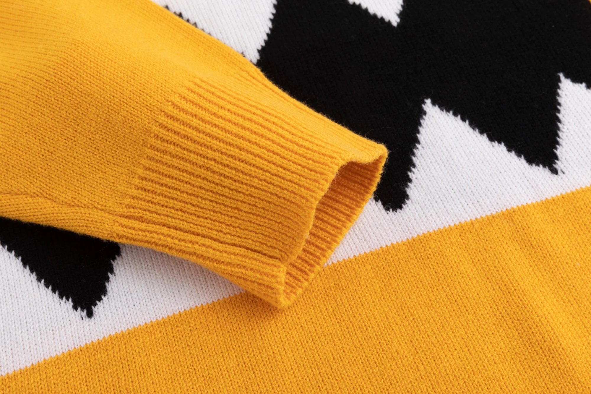 Close-up of the ribbed cuff beside the monster jacquard on the mustard yellow jumper.