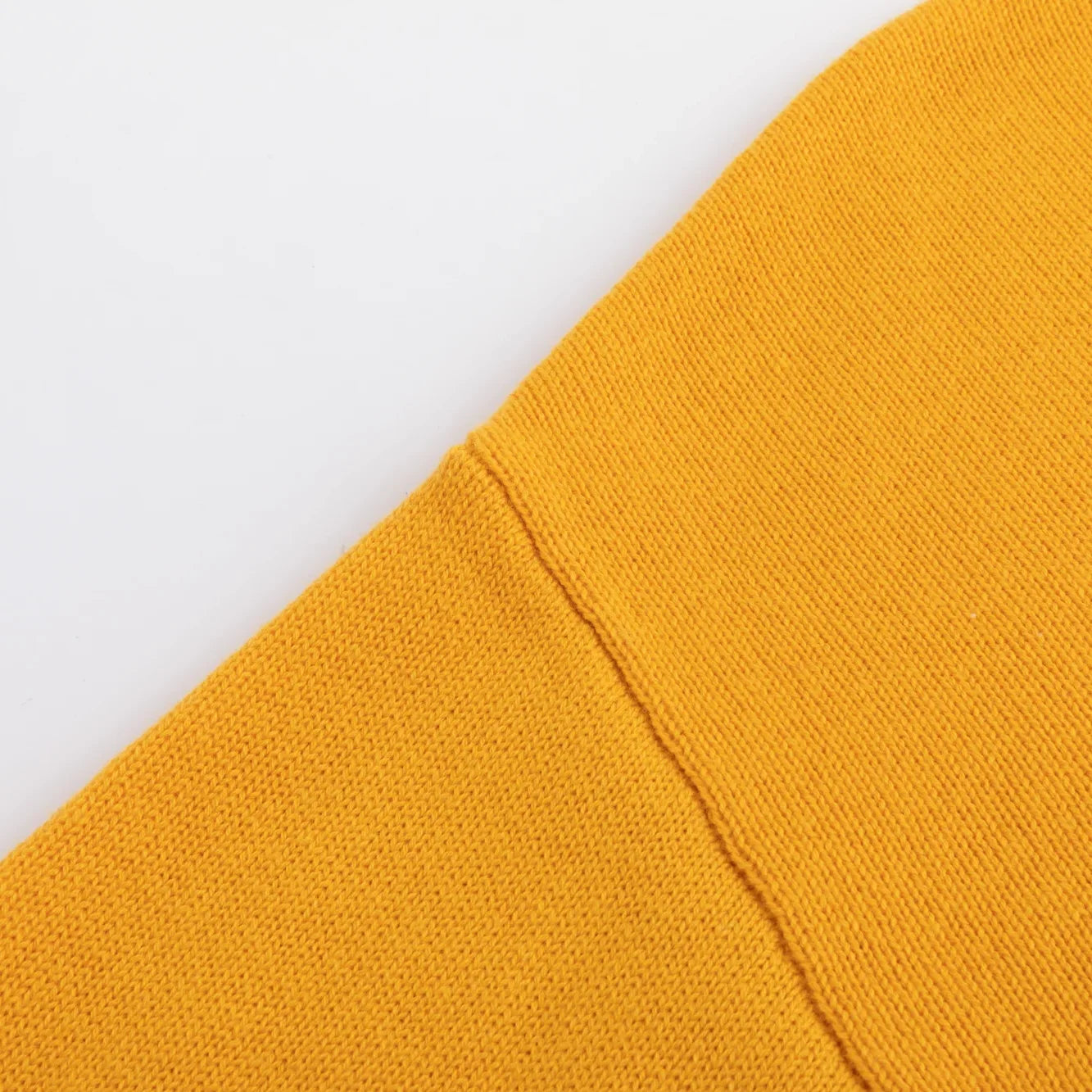 Close-up of the shoulder seam on the mustard yellow knit