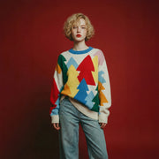 Model wearing an ivory merino wool jumper with a multicolour forest intarsia and an oversized dropped-shoulder fit.