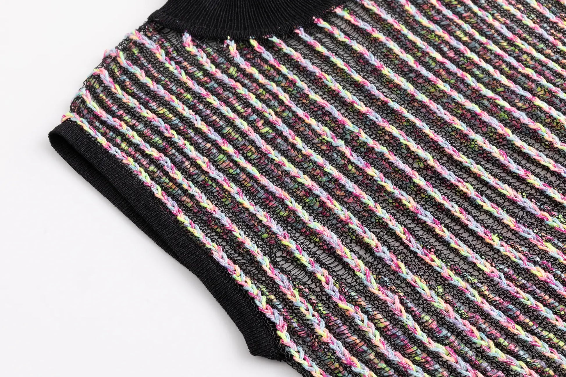 Close-up of the armhole and side edge on the black multicolour crochet mock neck top.