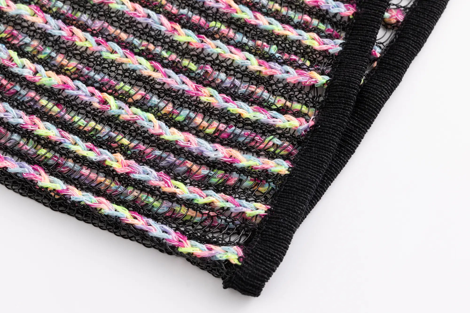 Close-up of the hem on the black multicolour crochet mock neck top with open striped texture.