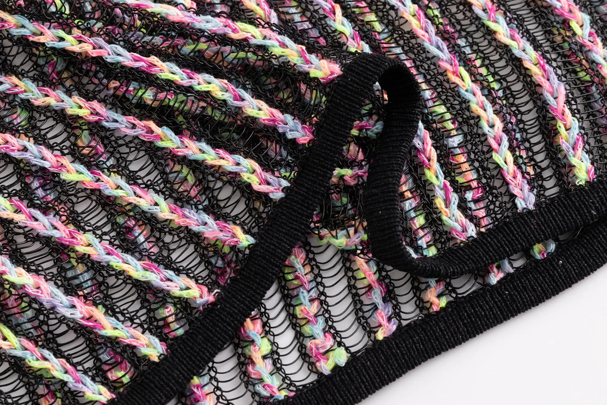 Close-up of the open crochet texture on the black multicolour top with fine vertical stripes.