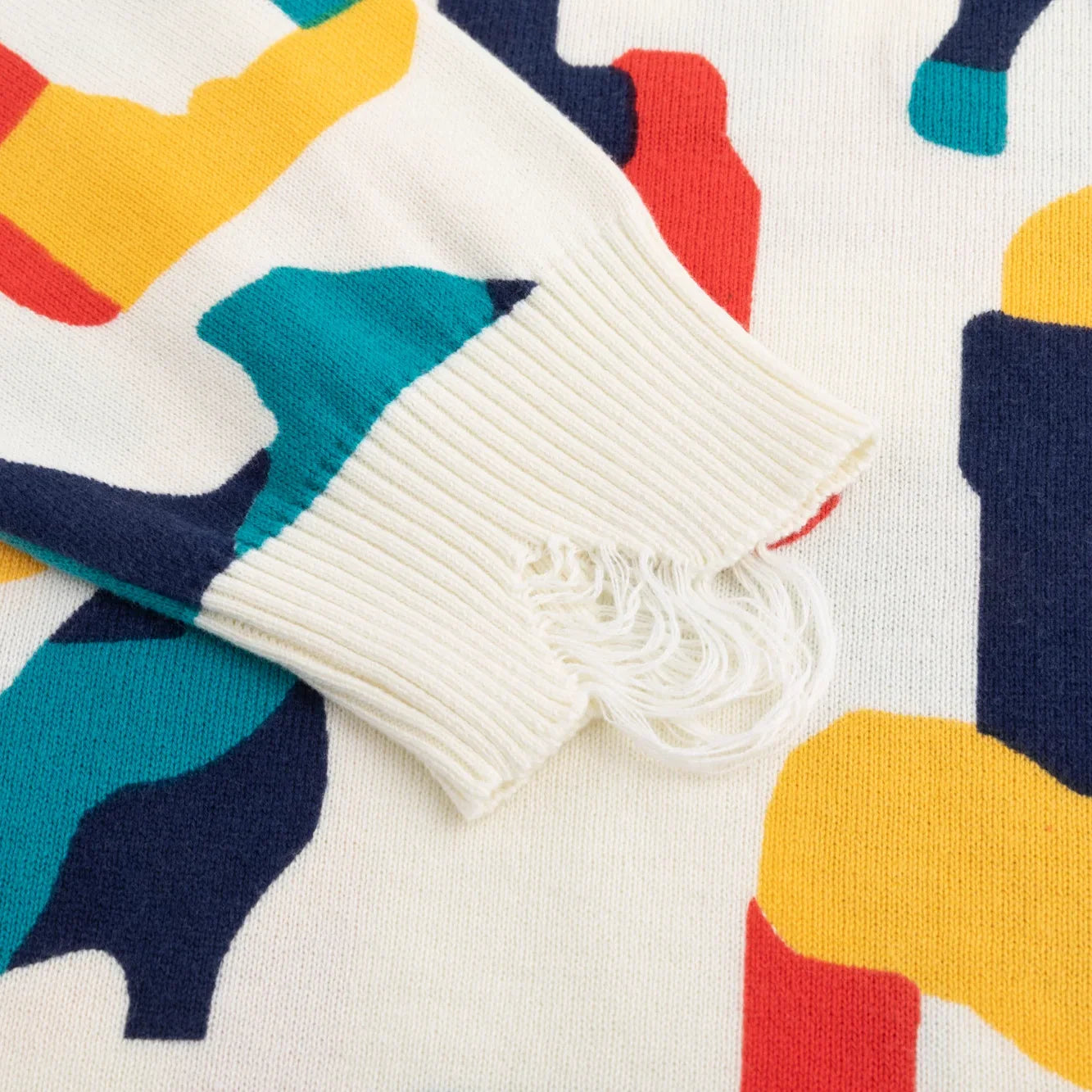 Close-up of the distressed ribbed cuff on the ivory multicolour jumper.